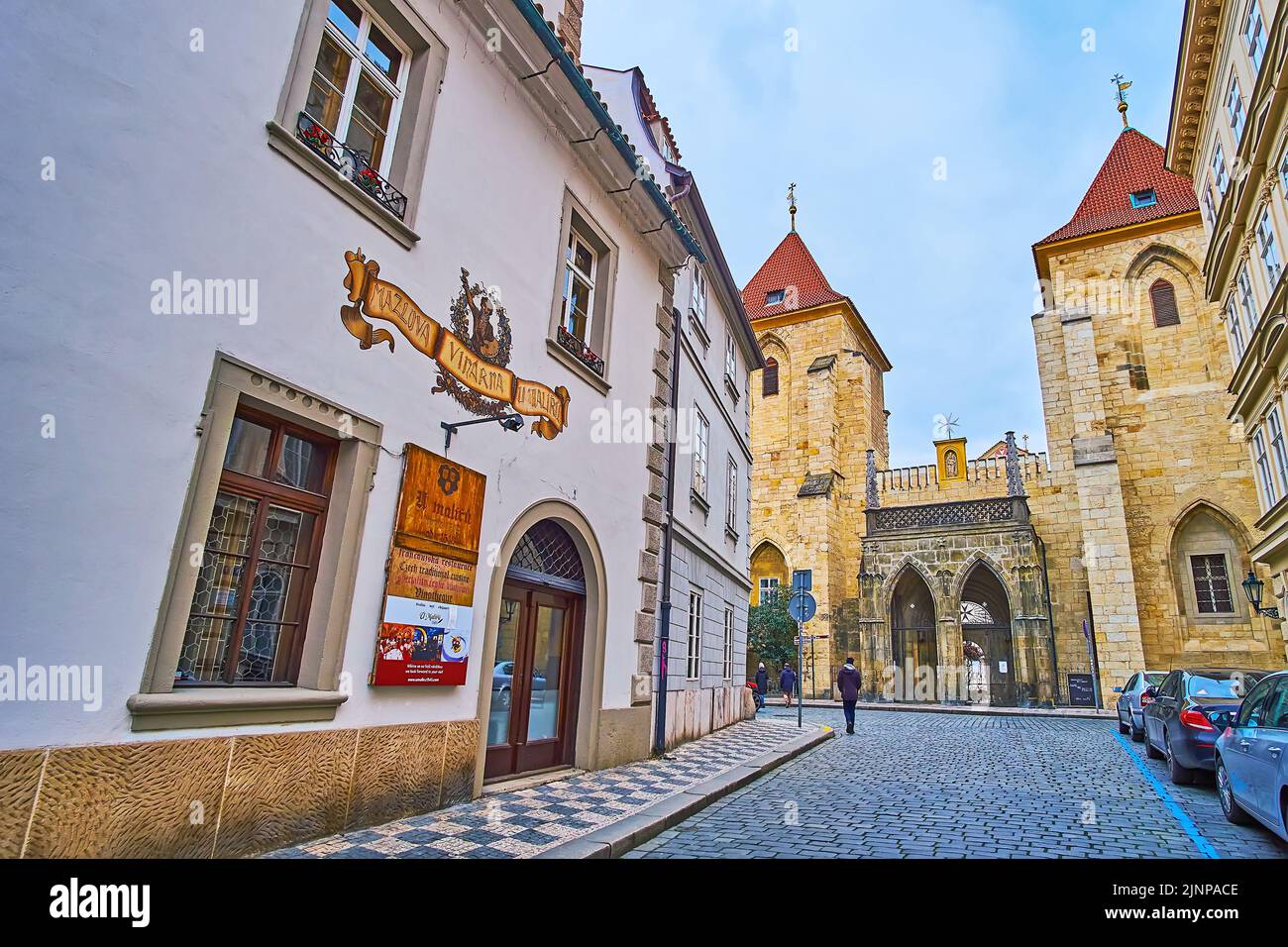 PRAGUE, CZECH REPUBLIC - MARCH 6, 2022: Lazenska Street of Lesser Quarter opens the view on the medieval gate and bell towers of Johannite Monastery, Stock Photo