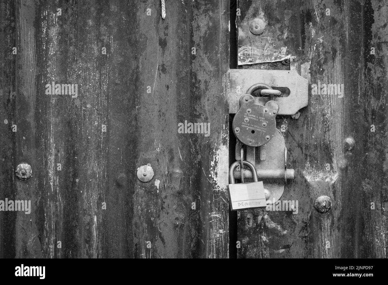Monochrome image of two padlocks on outdoor metal gateway. For locked out, data & email security, denial of service, Covid lockdown, keep out, access Stock Photo