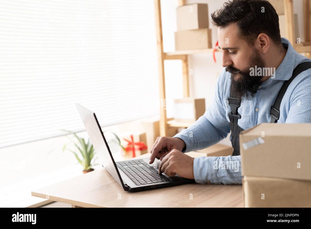 Indian entrepreneurs small business SME independent men work at home Use laptops for commercial checking, online marketing, packing boxes, SME sellers Stock Photo