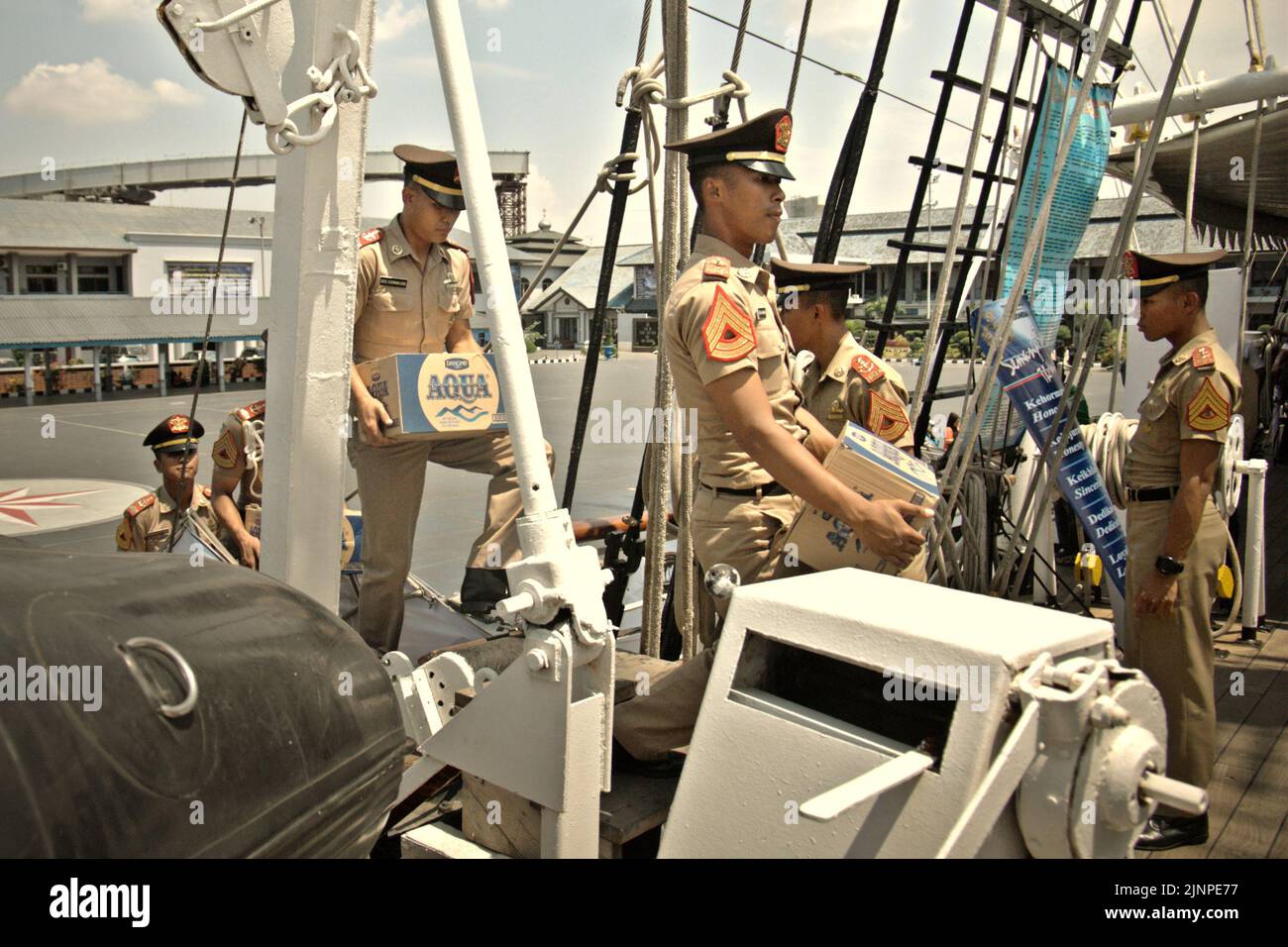 Navy cadets carrying mineral water in boxes as they are about to enter the cadet room on KRI Dewaruci (Dewa Ruci), an Indonesian tall ship, as the barquentine type schooner is opened for public visitors at Kolinlamil harbour (Navy harbour) in Tanjung Priok, North Jakarta, Jakarta, Indonesia. Stock Photo