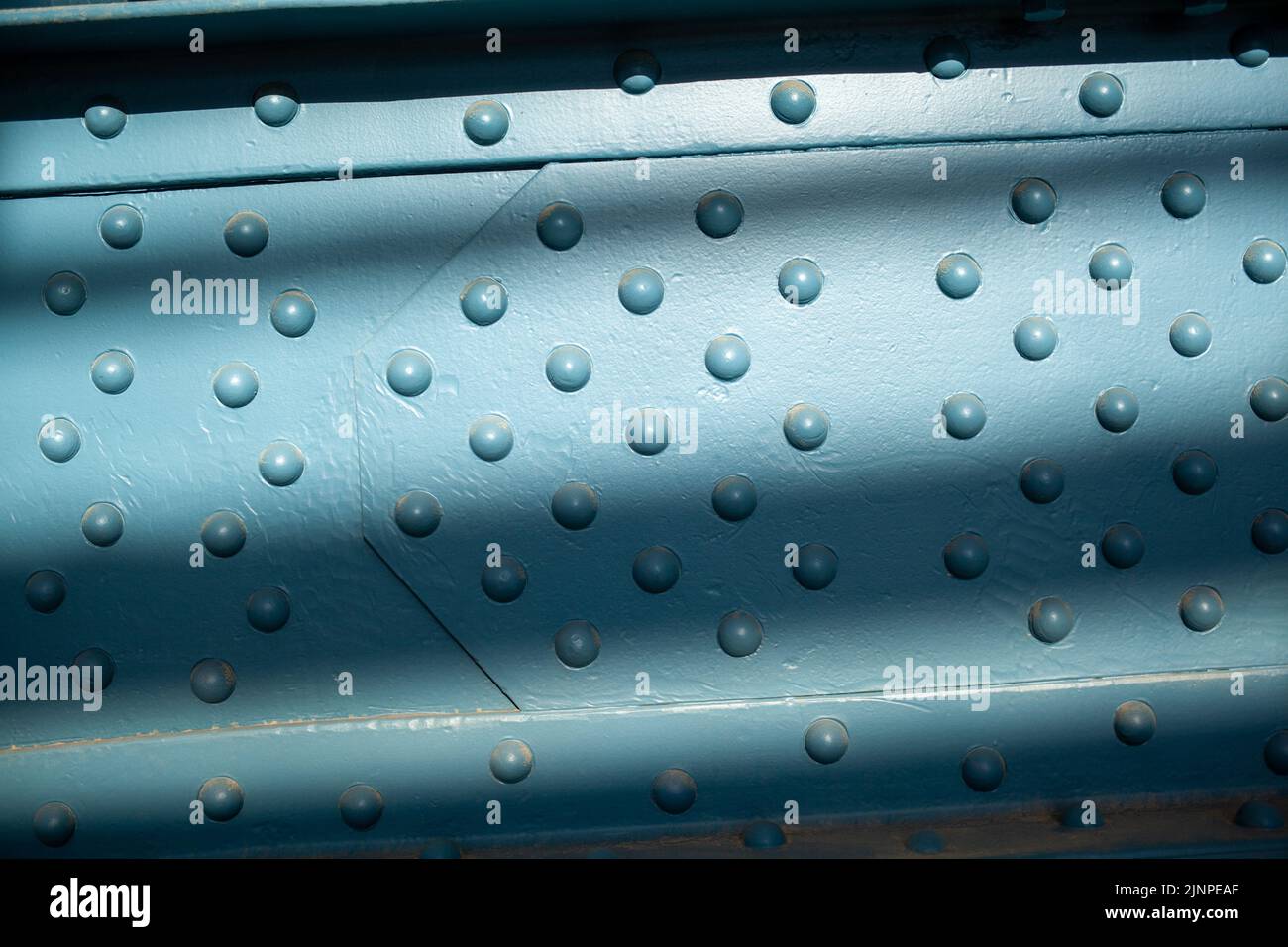Metal poles pedestrian covered bridge with lots of rivets. Powerful