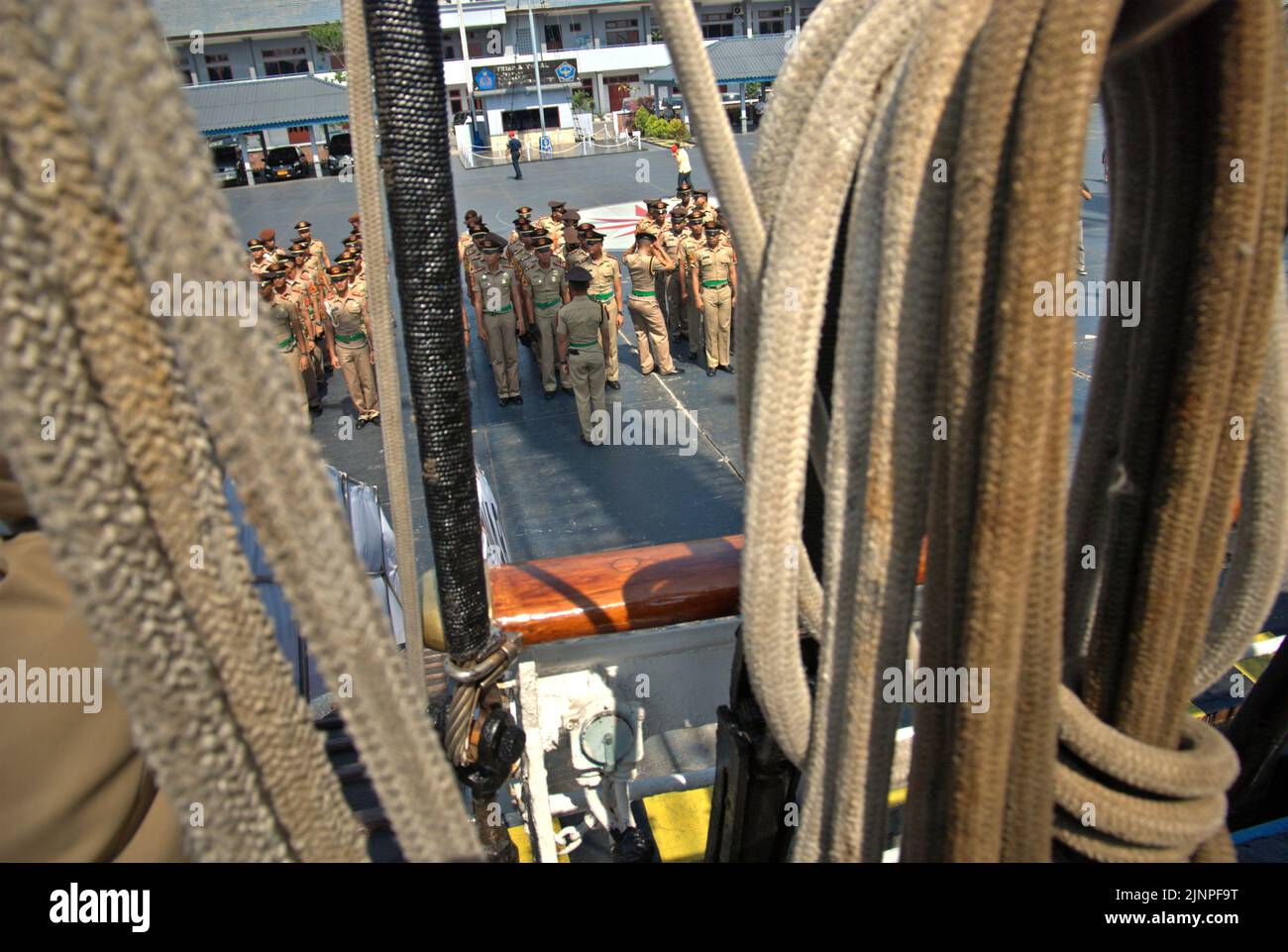Indonesian navy cadets and officers getting ready for a briefing, seen from KRI Dewaruci (Dewa Ruci), an Indonesian tall ship, as the barquentine type schooner is opened for public visitors at Kolinlamil harbour (Navy harbour) in Tanjung Priok, North Jakarta, Jakarta, Indonesia. Stock Photo