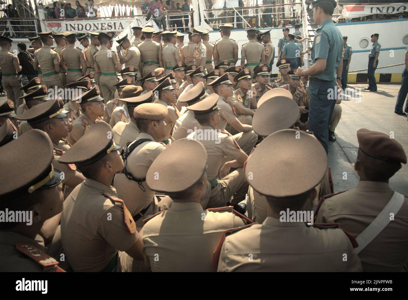 Indonesian navy cadets and officers attending a briefing, photographed from KRI Dewaruci (Dewa Ruci), an Indonesian tall ship, as the barquentine type schooner is opened for public visitors at Kolinlamil harbour (Navy harbour) in Tanjung Priok, North Jakarta, Jakarta, Indonesia. Stock Photo