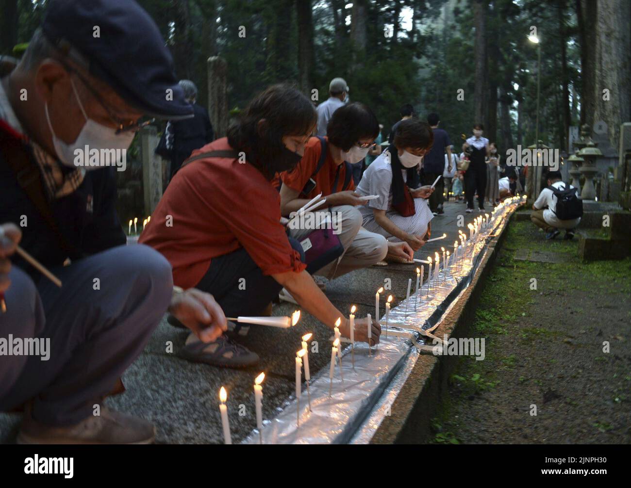 People light candles on a path leading to Okunoin temple during a candle festival in the Wakayama Prefecture town of Koya, western Japan, on Aug. 13, 2022. (Kyodo)==Kyodo Photo via Credit: Newscom/Alamy Live News Stock Photo