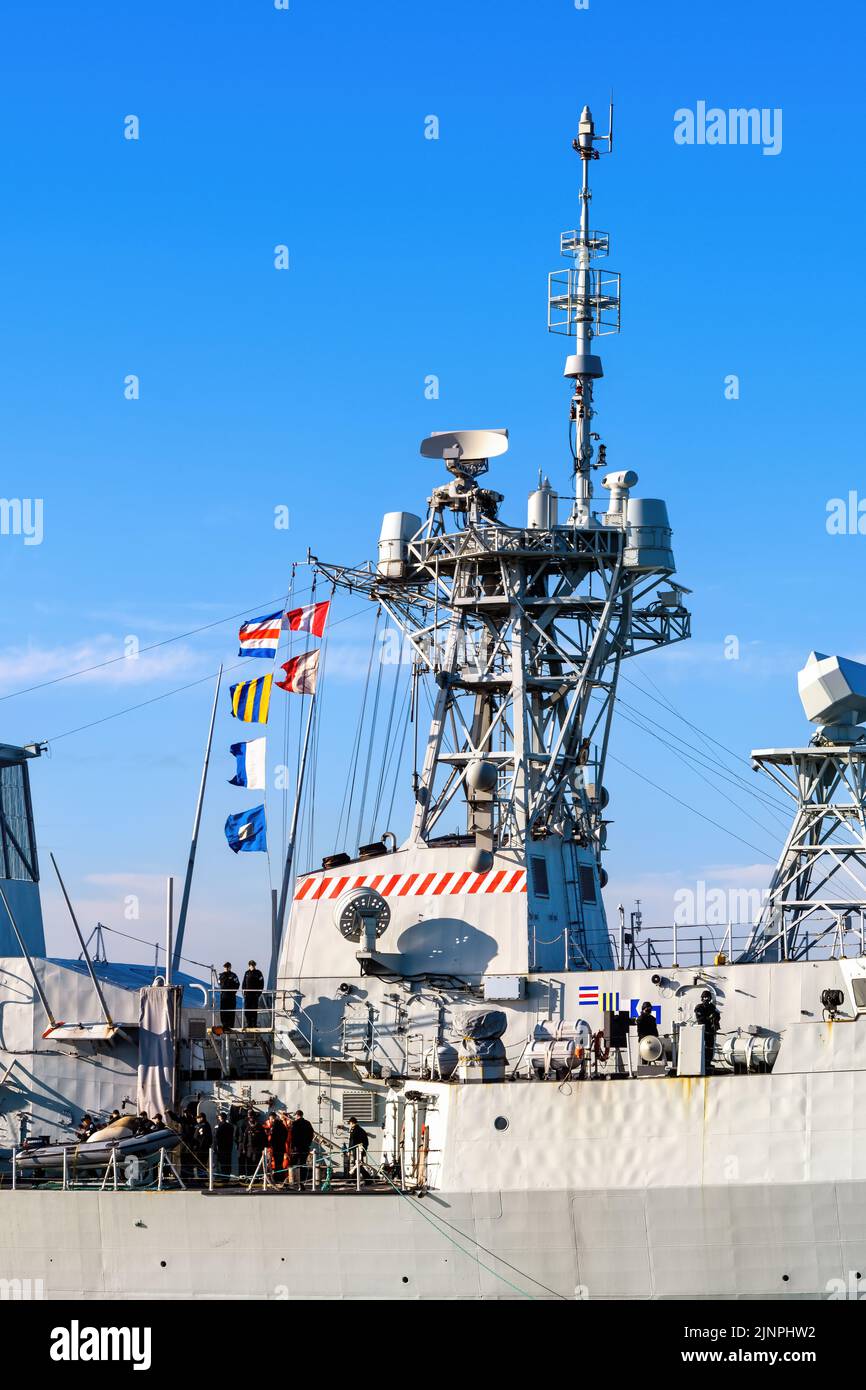 Signal flags displaying the callsign flying from the mainmast of a Canadian Halifax class frigate. Stock Photo