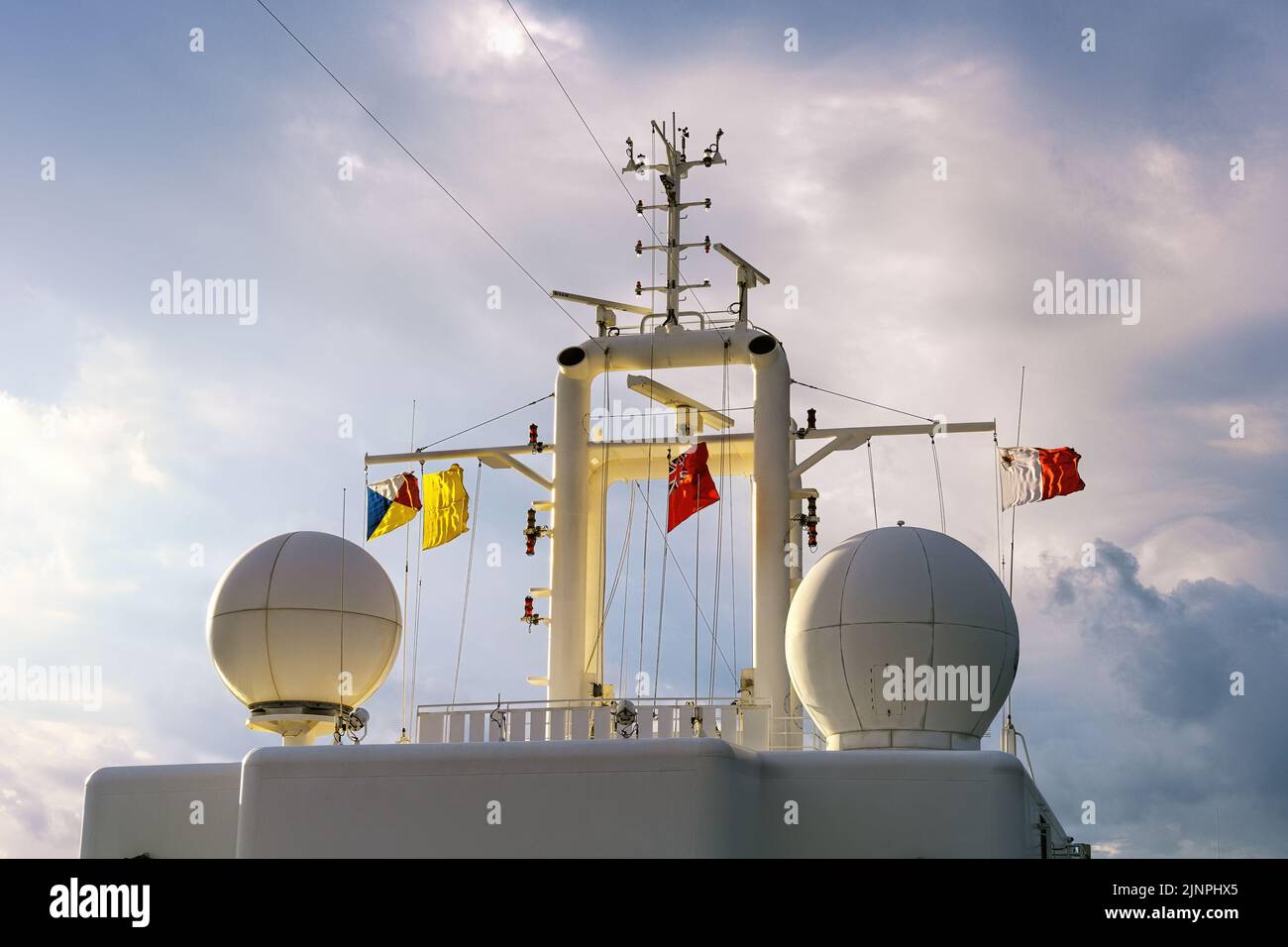 The signal deck of a P&O Cruises cruise ship with satellite domes, house flag, Red Ensign and Maltese courtesy flag - November 2018. Stock Photo