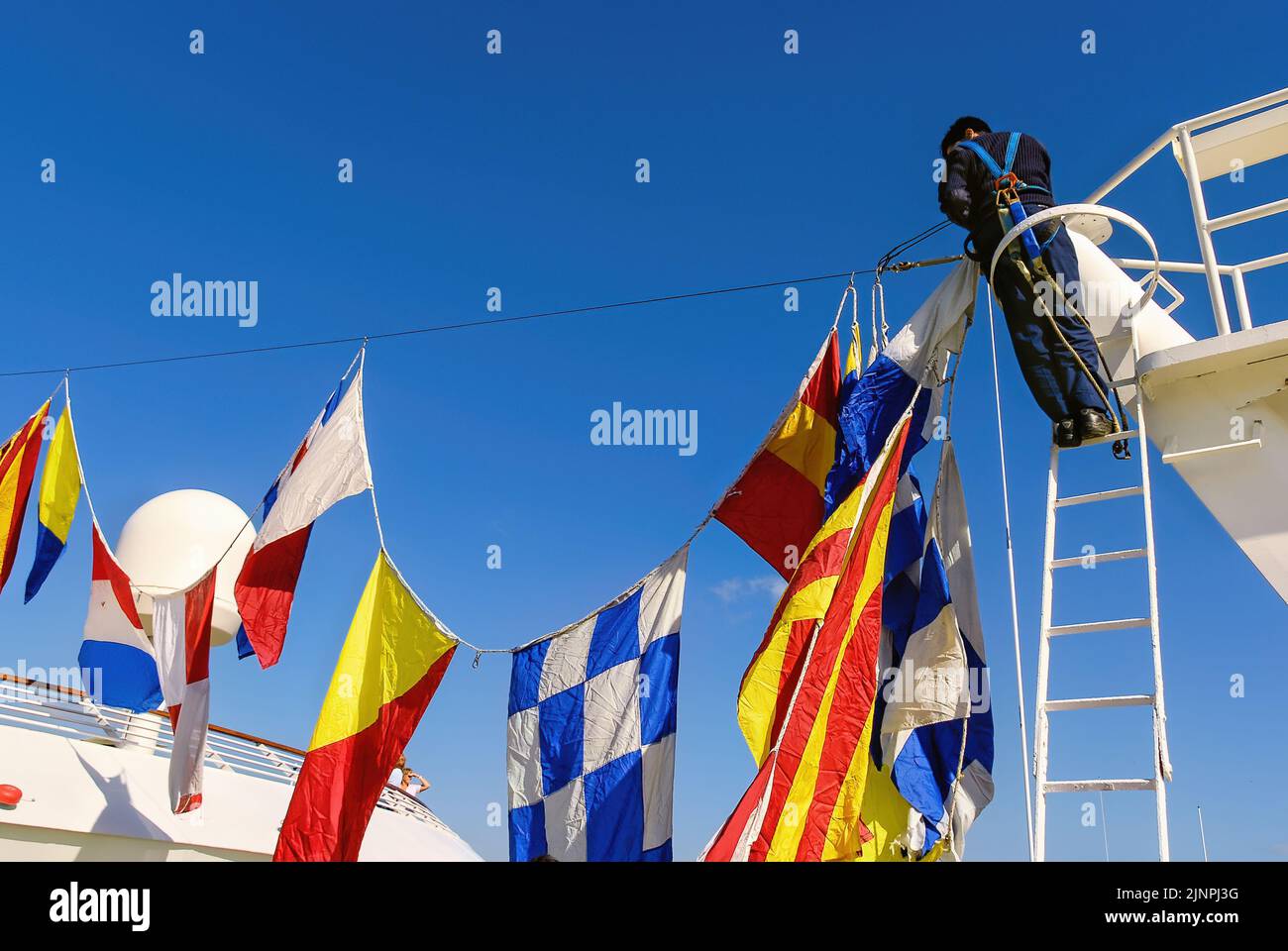 Dress ship is a nautical term for decorating a ship with International Maritime Signal Flags to mark a special occasion. Stock Photo