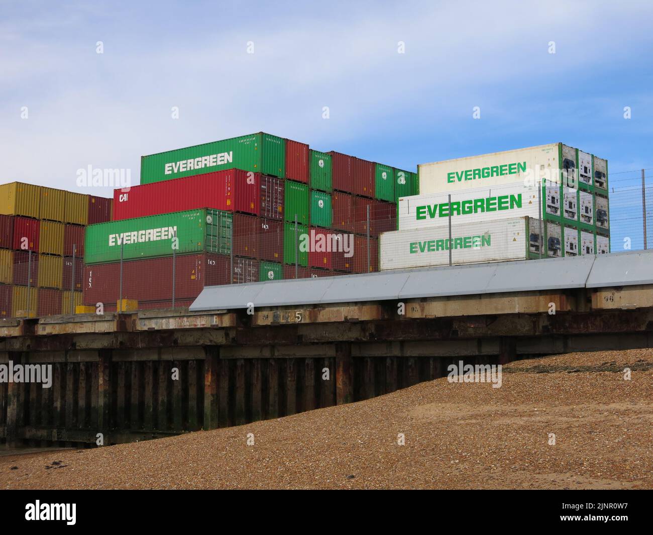 Evergreen shipping containers stacked up on the dockside at the Port of