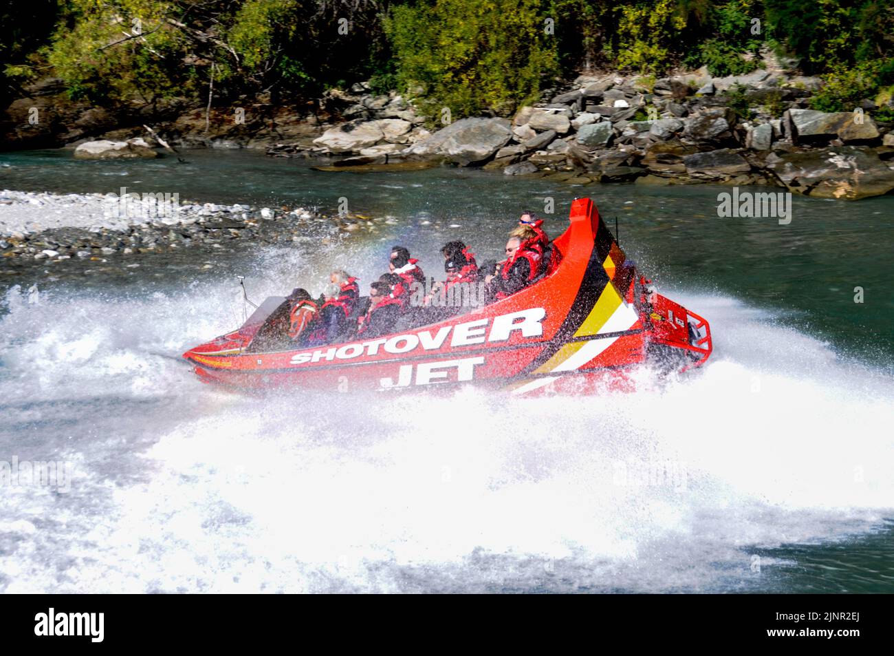Visitors enjoy the high-speed thrills on a Shotover jet flat bottom boat powered by twin 350 Mercruiser V8 engines, producing a combined 700 horse Stock Photo