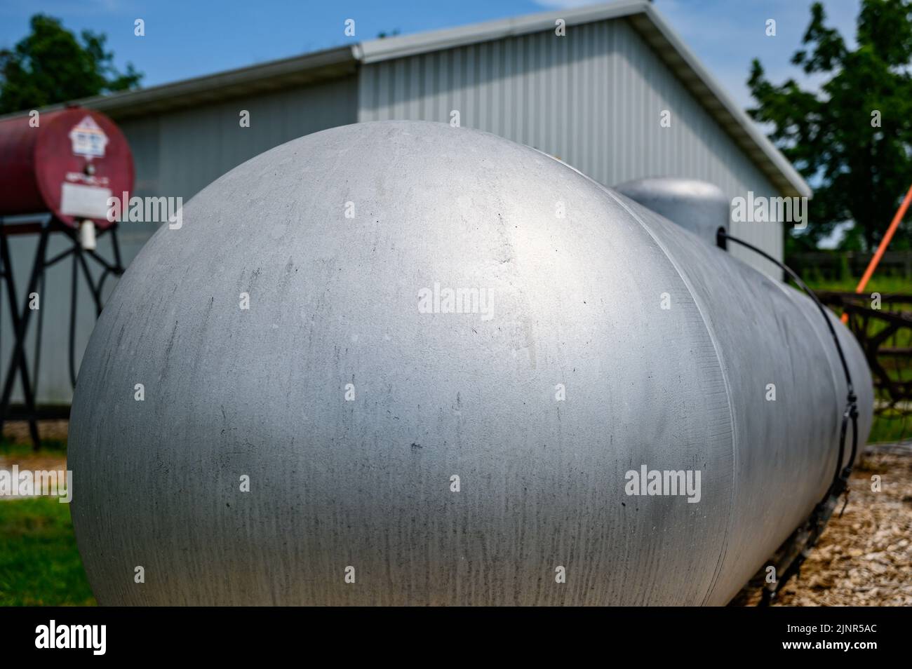 Silver painted liquid propane tank on rural property Stock Photo Alamy