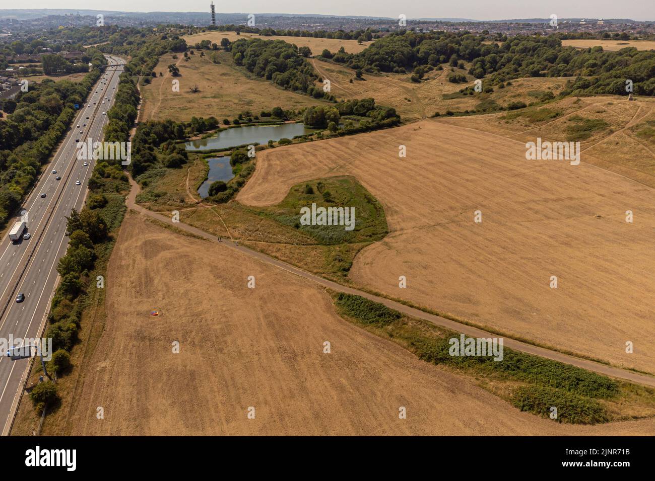 Dry grass fields next to the M32 motorway at Stoke Park, Bristol. The Met Office has issued an amber warning for extreme heat covering four days from Thursday to Sunday for parts of England and Wales. Picture date: Saturday August 13, 2022. Stock Photo