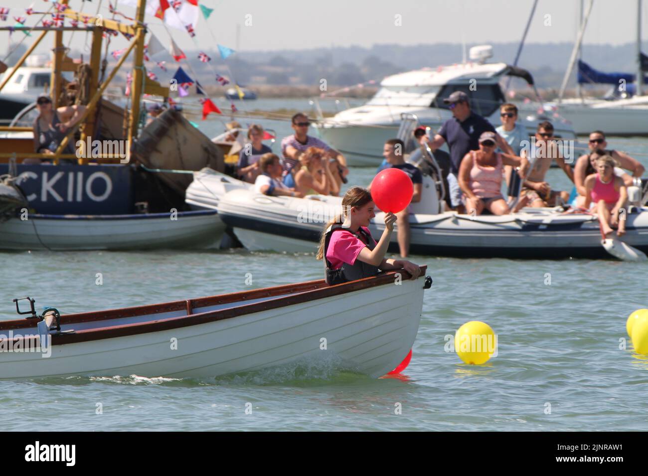 West Mersea Regatta is taking place on Mersea Island. The regatta has been run almost continually since 1838 and is organised by volunteers. The outboard dinghy balloon race in which competitors have to pick up balloons on the way to the finish line. Stock Photo