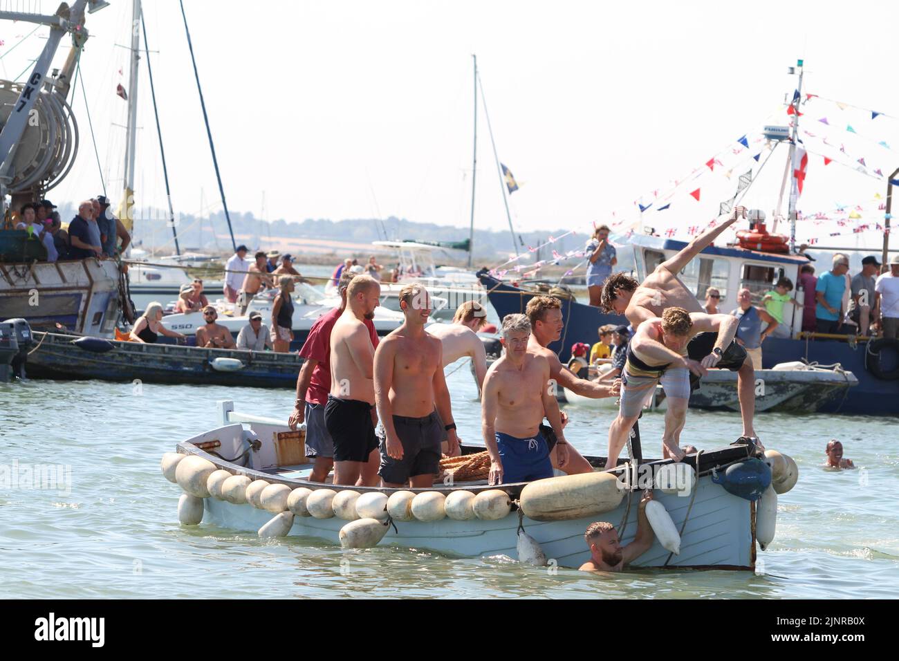 West Mersea Regatta is taking place on Mersea Island. The regatta has been run almost continually since 1838 and is organised by volunteers. Swimmers diving into the water ready for the start of the swimming race. Stock Photo