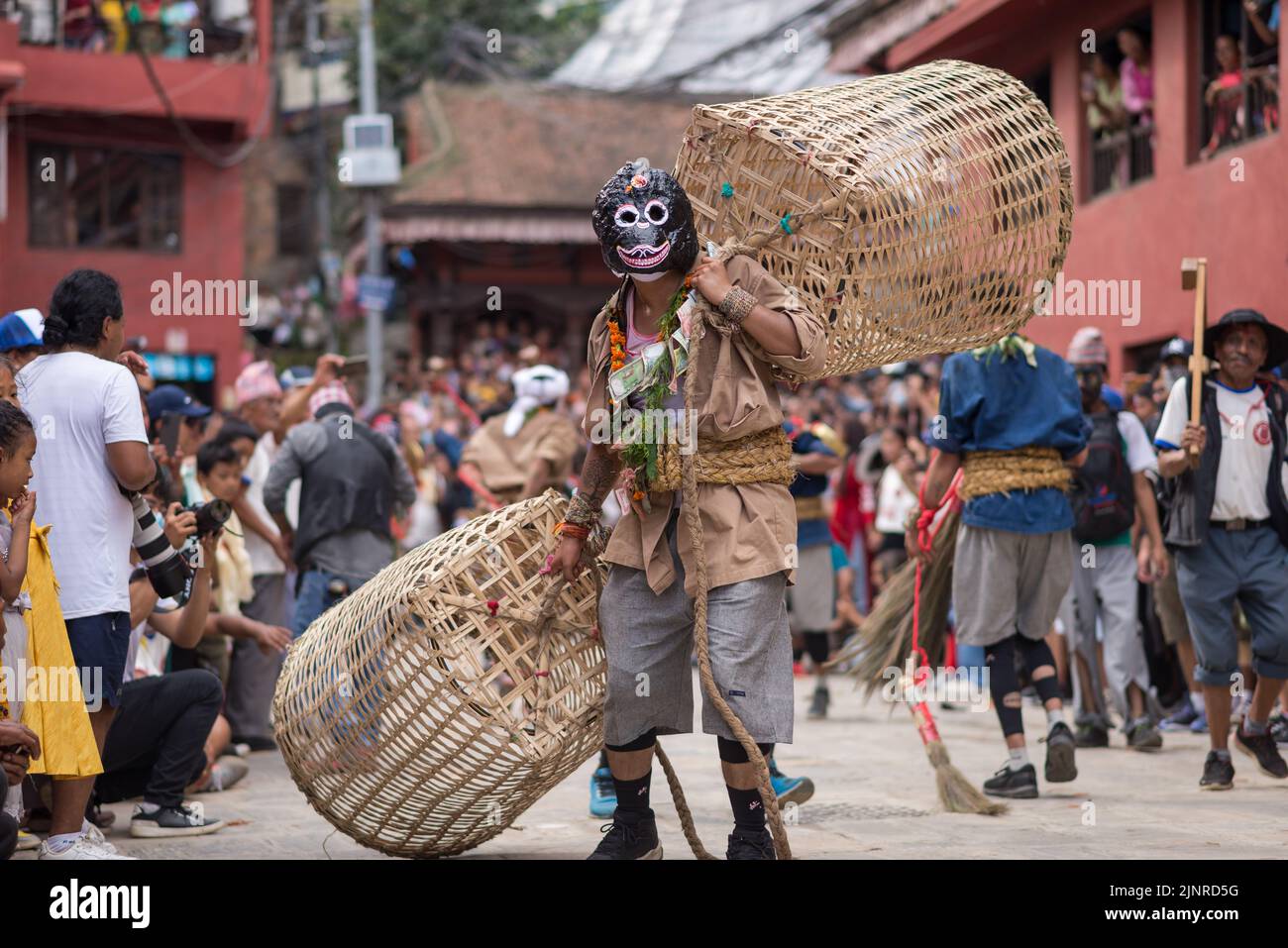 A man dressed in a traditional costume performs a holy dance during the festival. People celebrate Gai Jatra or cow festival in memory of the departed souls in the past year for salvation and peace. It is believed that cows guide the departed souls to cross the river to get to heaven. Stock Photo