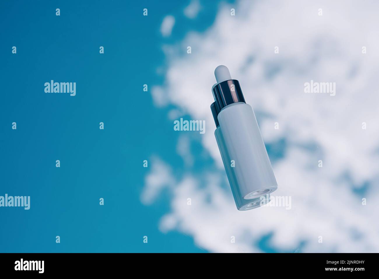Cosmetic background, white Bottle with a pipette on a blue sky background Stock Photo