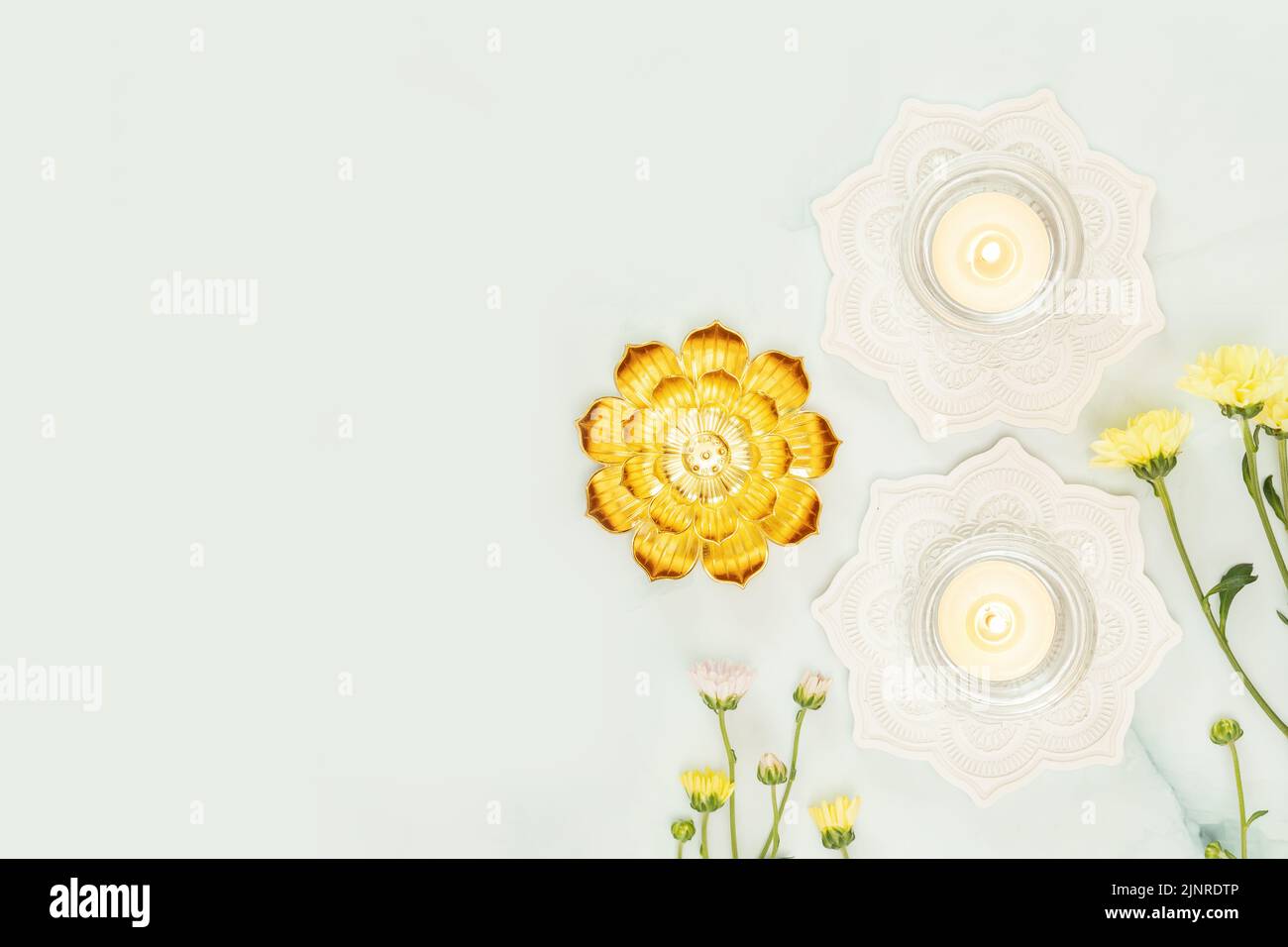 Flowers and candles on a light blue background with hindu decorations and copy space. Hindu religion background suitable for Diwali, vesak day and Gan Stock Photo