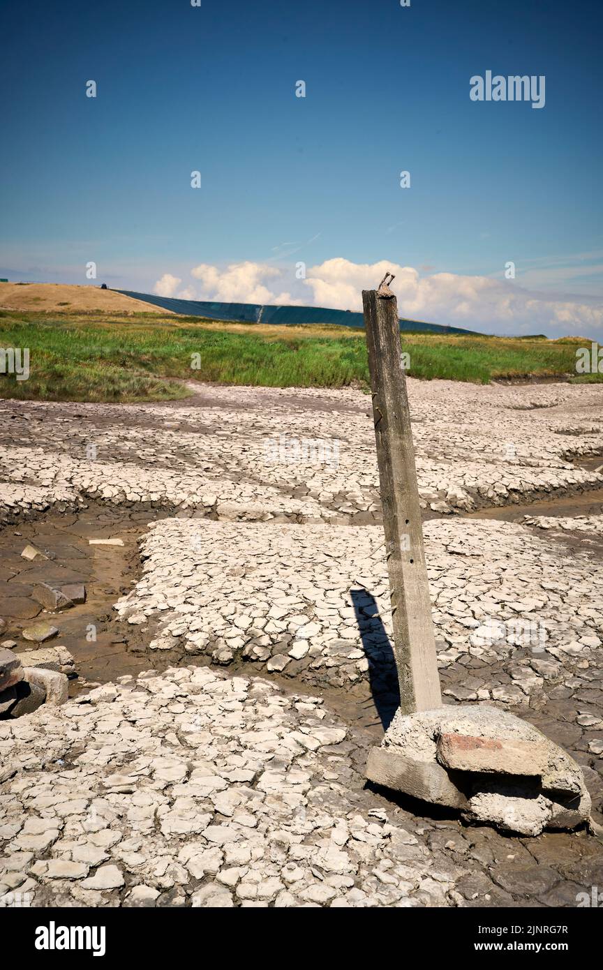 Wooden marker post stick up in dried up water channel Stock Photo