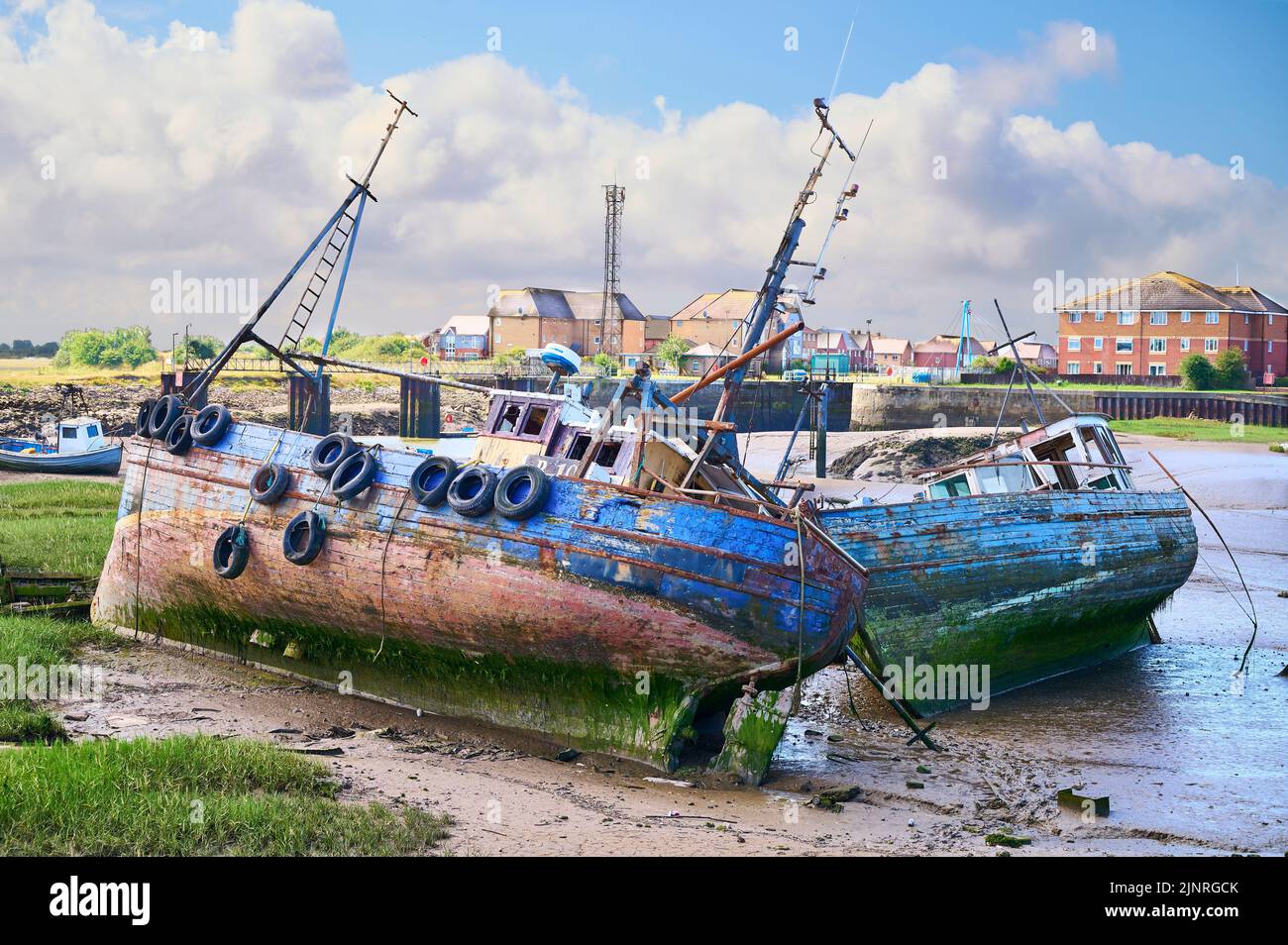 Abandoned fishing vessels in Jubilee Dock,Fleetwood at low tide in summer Stock Photo