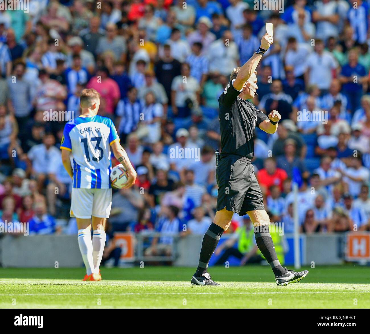 Brighton, UK. 13th Aug, 2022. Alexis Mac Allister of Brighton and Hove Albion receives a yellow card for pulling on the shirt of Miguel Almiron of Newcastle United during the Premier League match between Brighton & Hove Albion and Newcastle United at The Amex on August 13th 2022 in Brighton, England. (Photo by Jeff Mood/phcimages.com) Credit: PHC Images/Alamy Live News Stock Photo