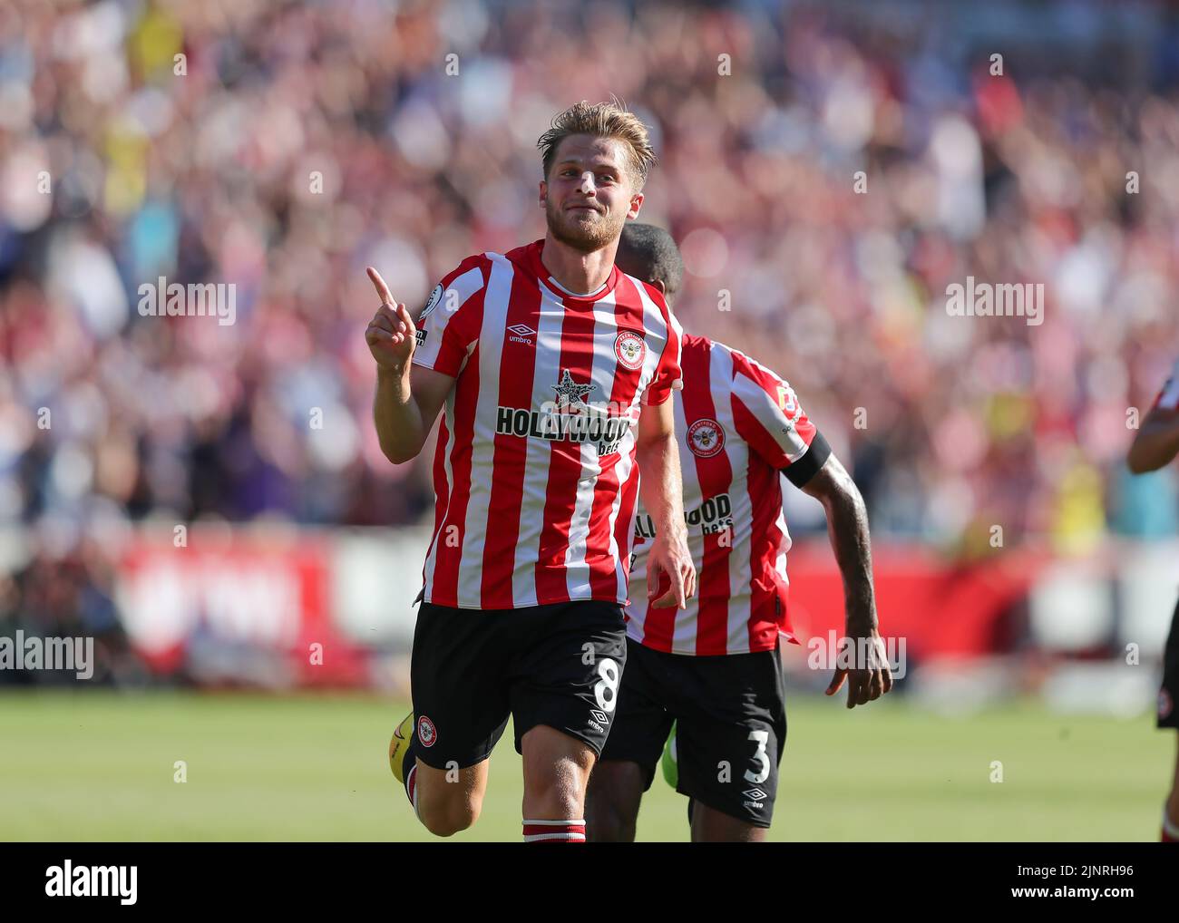 13th August 2022; Gtech Community Stadium, Brentford, London, England; Premier League football, Brentford versus Manchester United ; Mathias Jensen of Brentford celebrates towards the Man United fans after scoring his sides 2nd goal in the 18th minute to make it 2-0 Stock Photo
