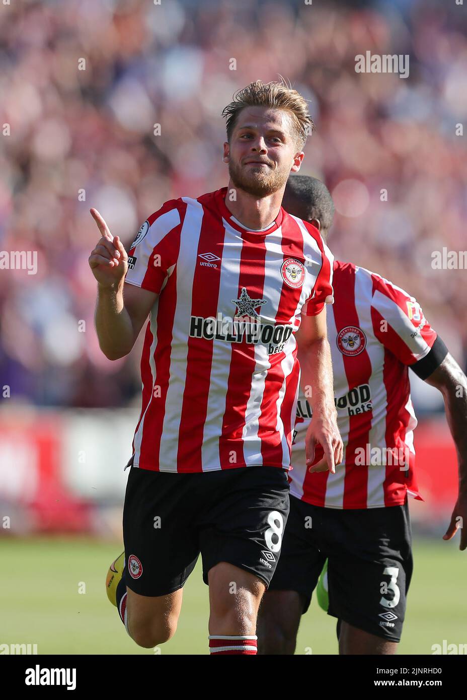 13th August 2022; Gtech Community Stadium, Brentford, London, England; Premier League football, Brentford versus Manchester United ; Mathias Jensen of Brentford celebrates towards the Man United fans after scoring his sides 2nd goal in the 18th minute to make it 2-0 Stock Photo