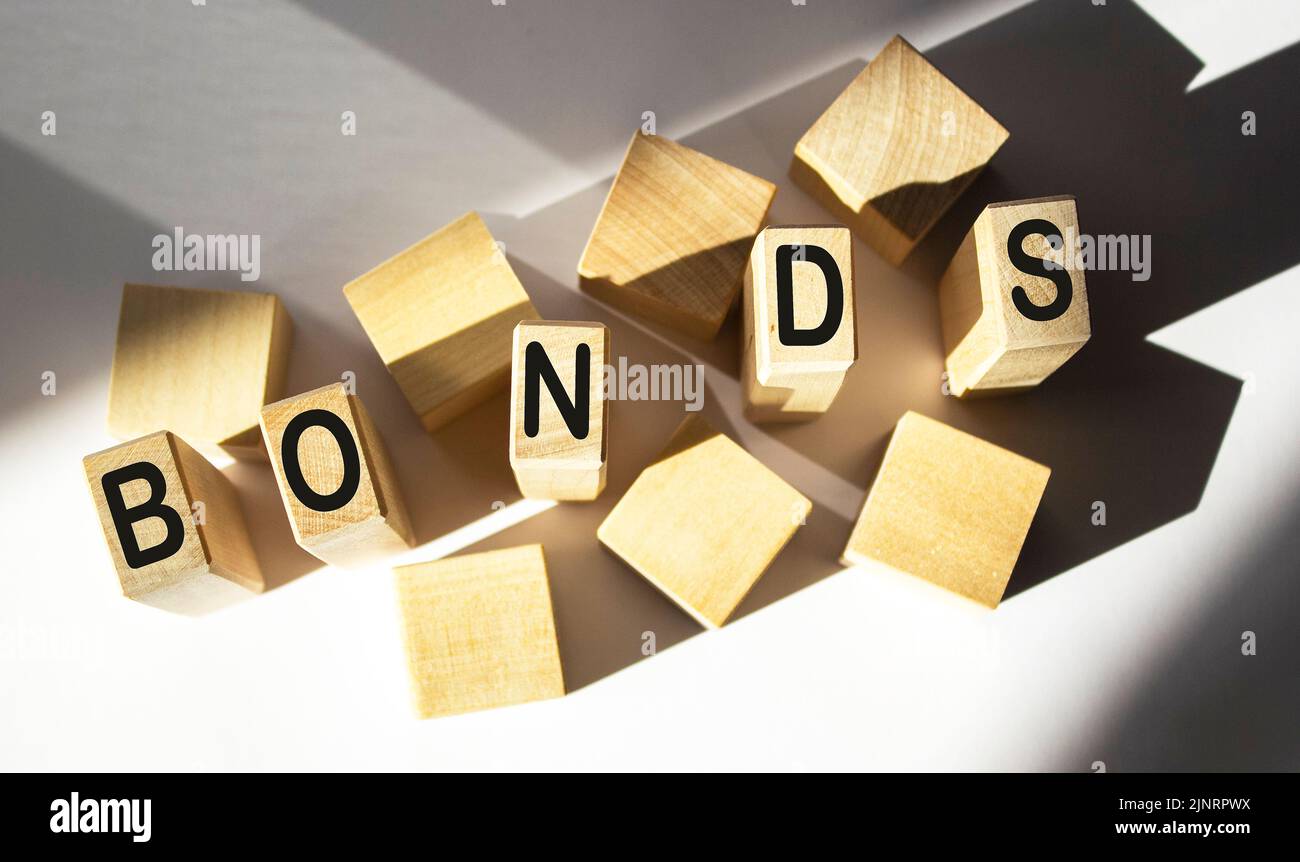Wooden blocks with the word Bonds on a white background. A bond is a security that indicates that an investor has provided a loan to the issuer. loan Stock Photo