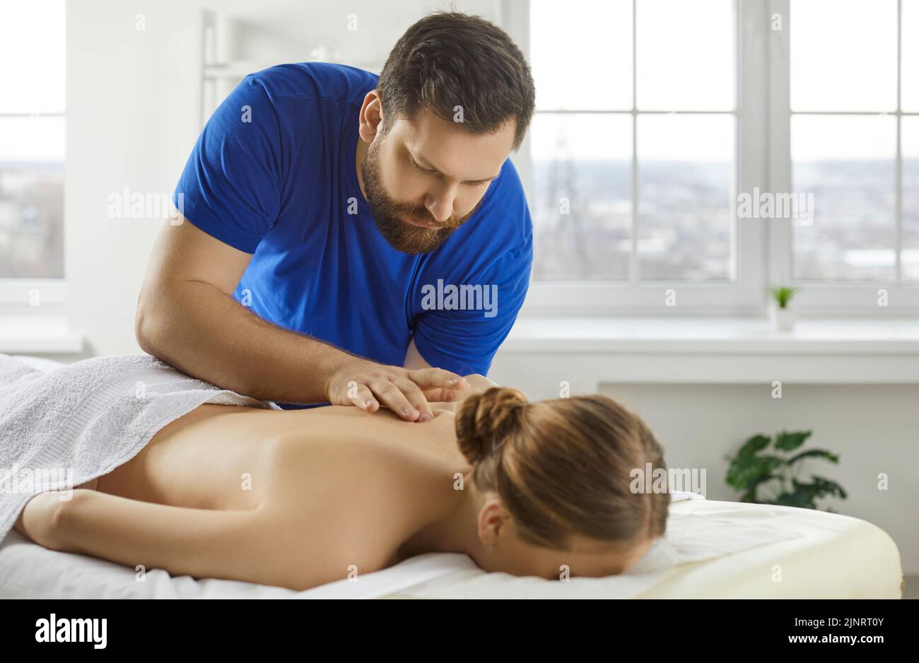 Therapist massage female patient in saloon Stock Photo