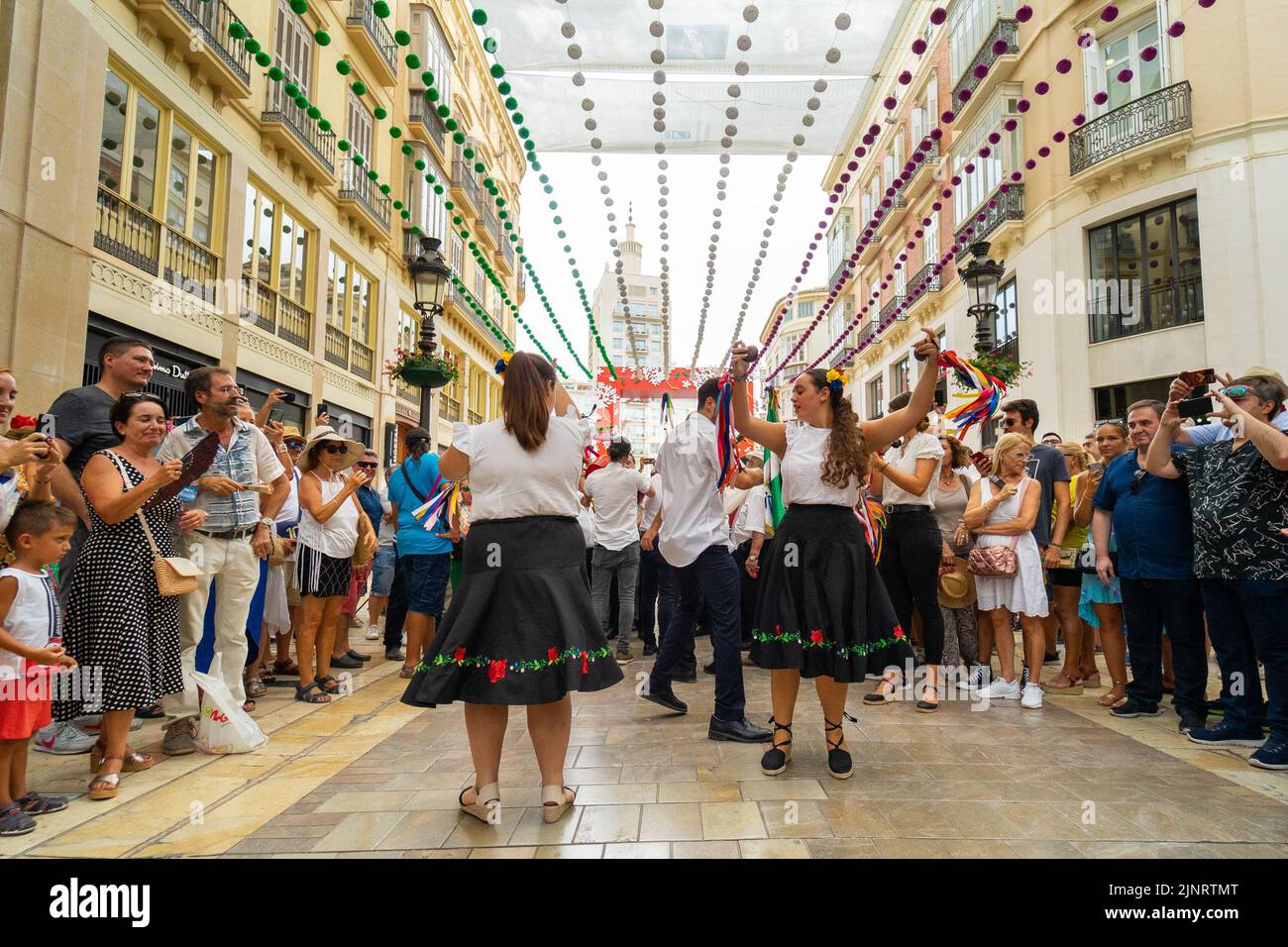Three persons seen dancing 'verdiales' at Marques de Larios Street during the first day of Malaga's Fair 2022. The Fair is being held for the first time since 2019. The 2020 and 2021 editions were suspended due to Covid19 pandemic. Stock Photo