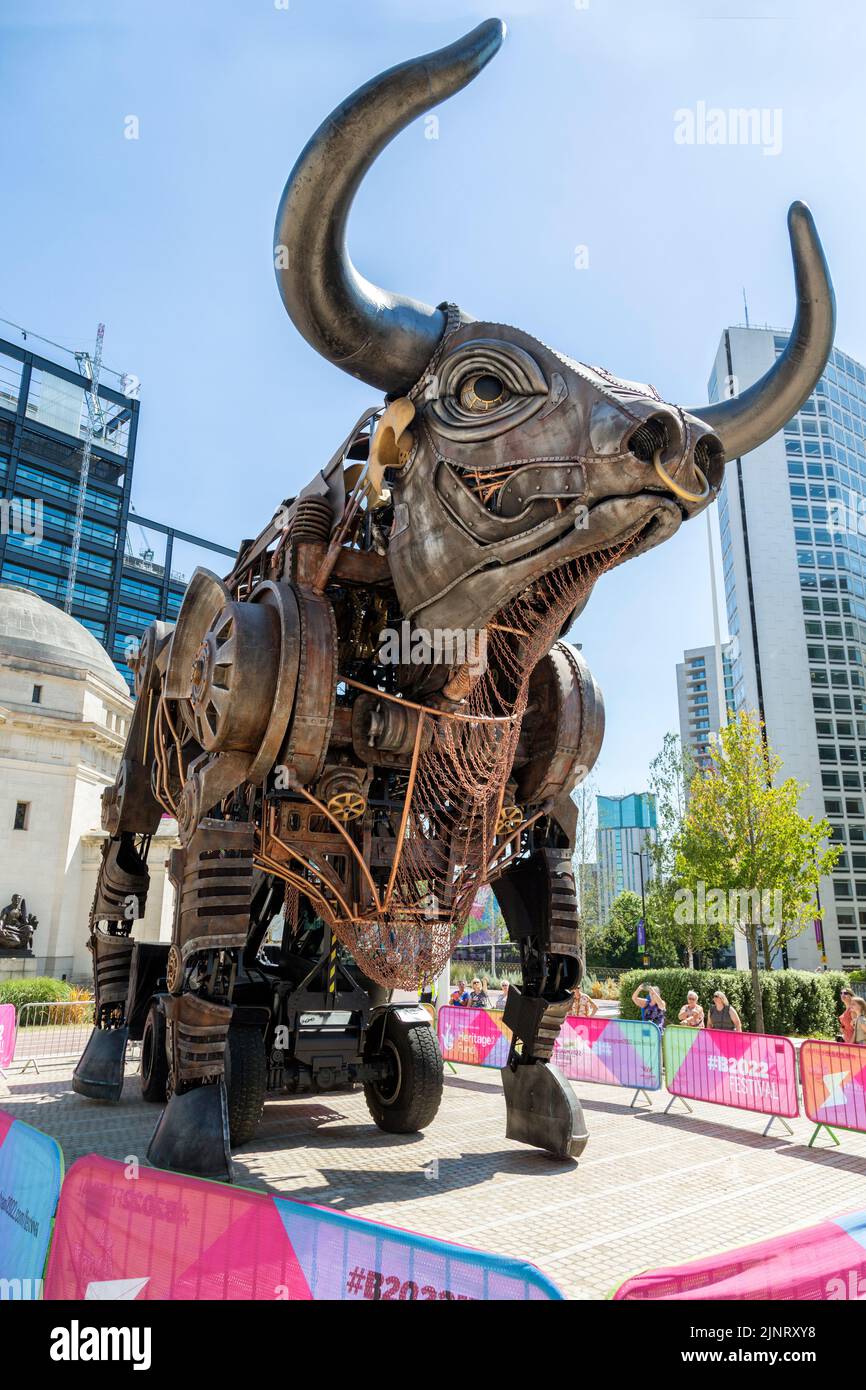 People look in wonder at the iconic 10 metre high raging bull from the 2022 Commonwealth Games opening ceremony. Centenary Square, Birmingham, Stock Photo