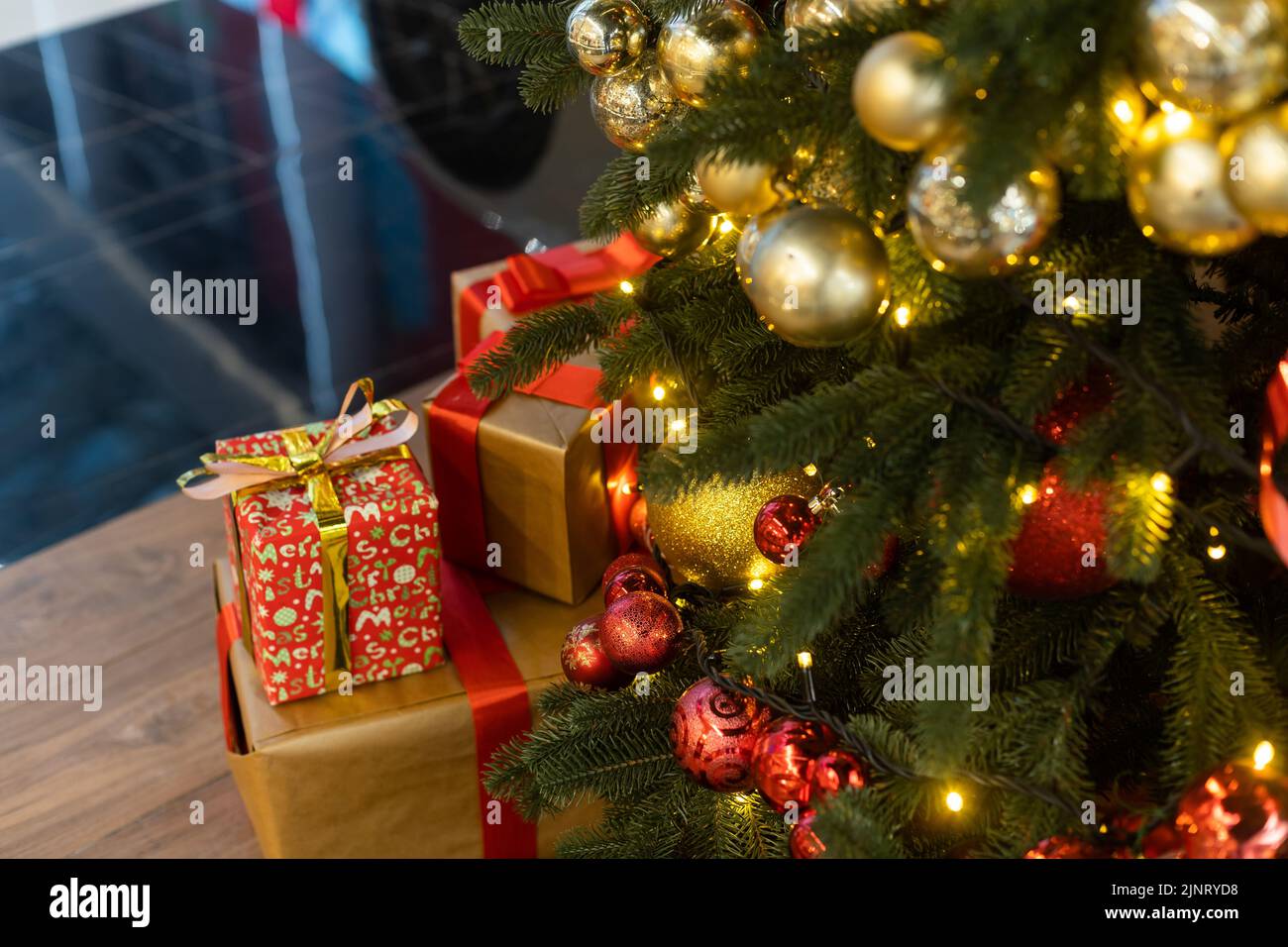 Beautiful Christmas gift boxes on floor near fir tree in room Stock ...