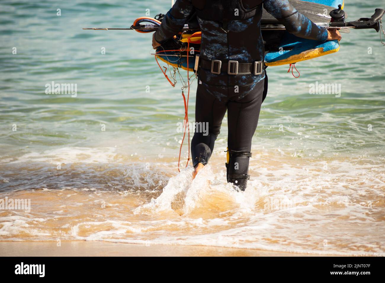 Salvador, Bahia, Brazil - June 04, 2022: Man entering the sea with diving equipment. Porto da Barra beach, in Salvador, state of Bahia, Brazil. Stock Photo