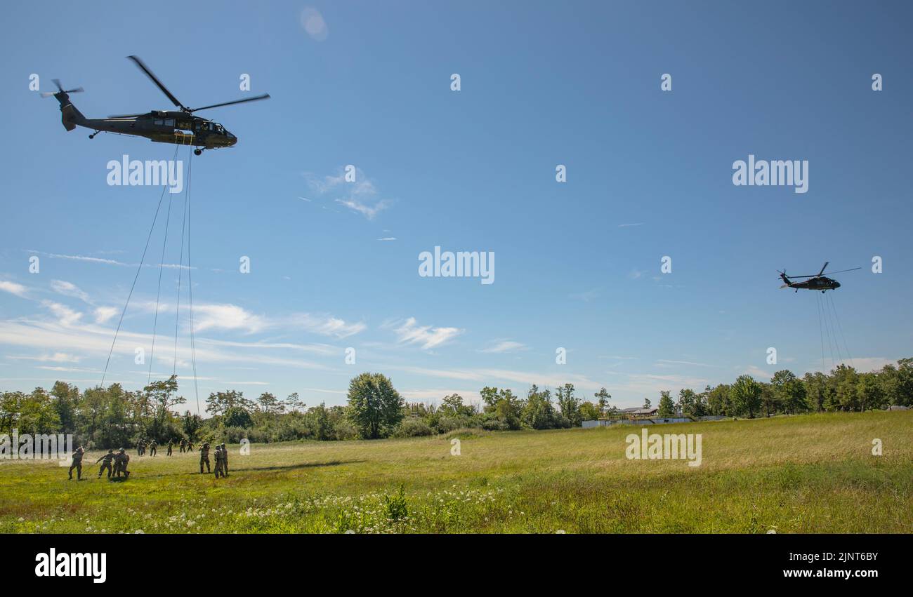 Two UH-60 Black Hawk helicopters hover as Soldiers rappel during Air Assault School at Fort Indiantown Gap, Pa, on August 11, 2022 . Air Assault School is a 10-day course designed to prepare Soldiers for insertion, evacuation, and pathfinder missions that call for the use of multipurpose transportation and assault helicopters. (U.S. Army photo by Sgt. Kenneth Shirk) Stock Photo