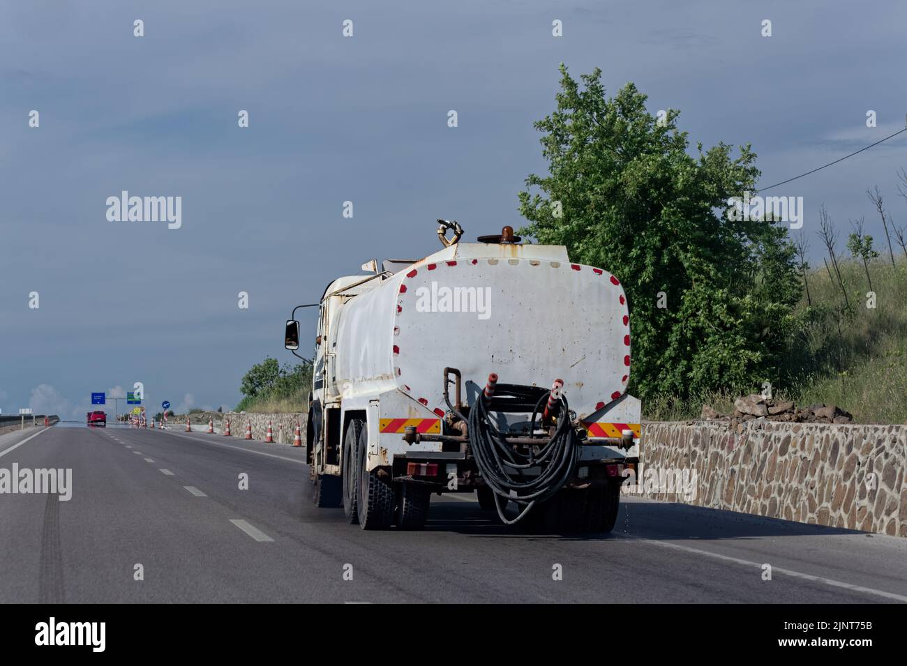 Small truck carrying liquid raw material on the highway road. Stock Photo