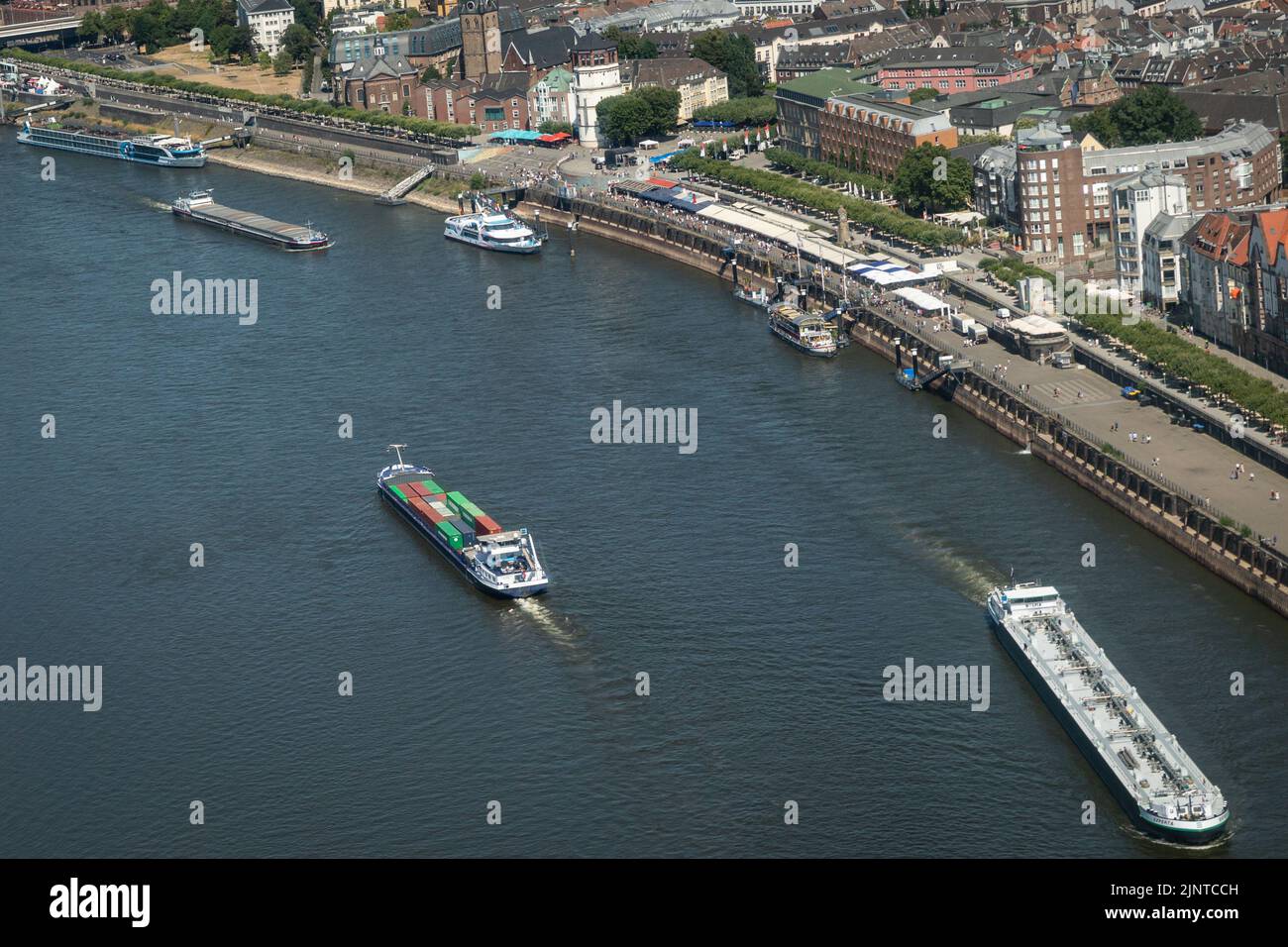 Düsseldorf, NRW, Germany, 13th Aug 2022. The riverbanks look parched and wider from above, whilst freight vessels have to carefully navigate the narrowed shipping lane. The River Rhine, one of the busiest inland waterways in the world, has been strongly affected by the ongoing drought and resulting low water levels, caused by prolonged heat of up to 40 degrees and very little rain in the last few weeks. The shipping lane has narrowed down considerably, slowing down traffic, most vessels have also had to considerably reduce their freight weight, leading to supply issues and higher shipping pric Stock Photo