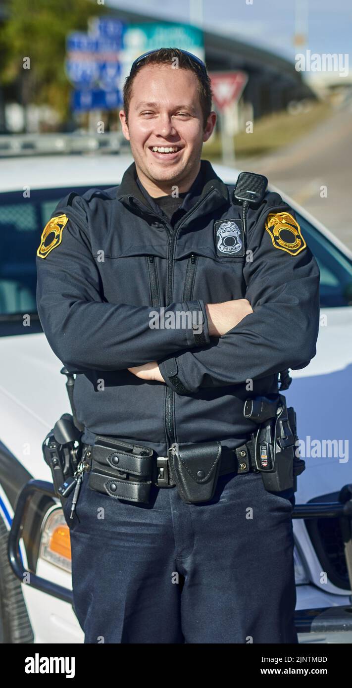 Patrolling the streets. Cropped portrait of a handsome young policeman standing with his arms crossed while out on patrol. Stock Photo