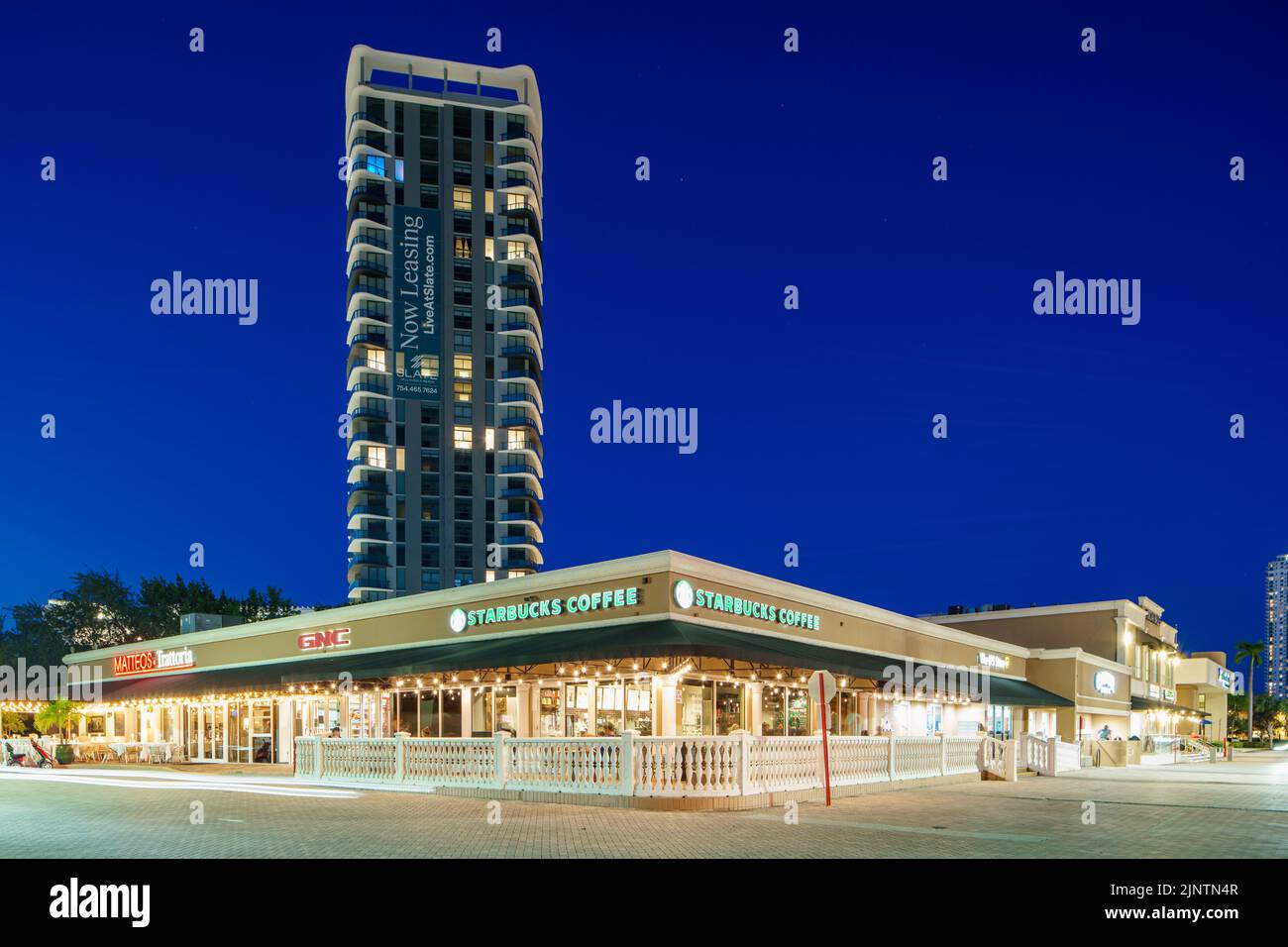 Hallandale Beach, FL, USA - July 31, 2022: Night photo Slate Hallandale rental condo and Starbucks Coffee Stock Photo