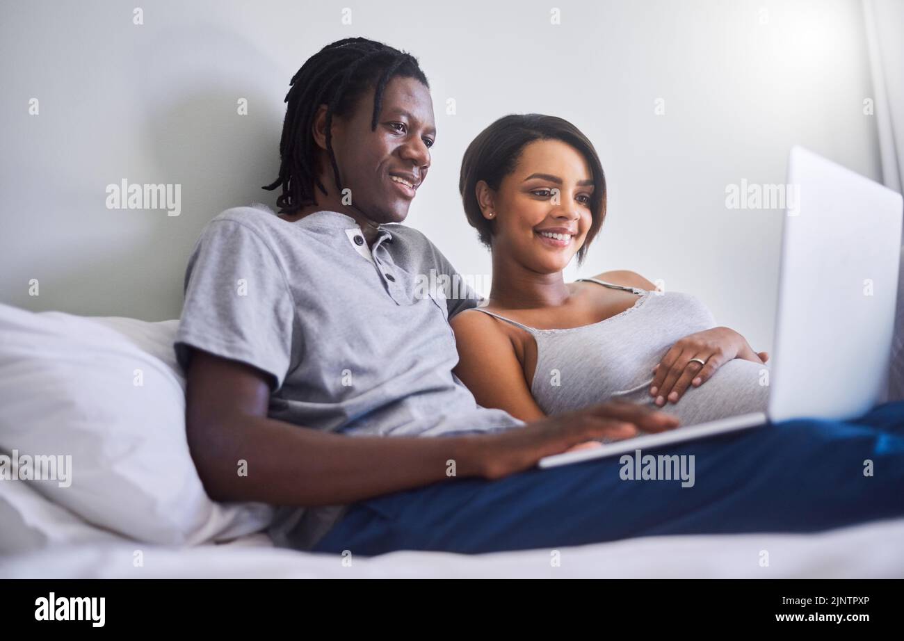 Lets check what this week of pregnancy holds. an expecting couple browsing the internet at home. Stock Photo