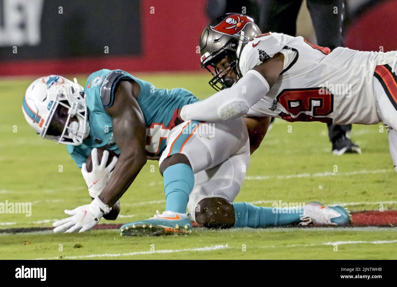 Tampa, United States. 13th Aug, 2022. Tampa Bay Buccaneers' Cam Gill (R) brings down Miami Dolphins' Trent Sheffield (L) during the first half of their preseason game at Raymond James Stadium in Tampa, Florida on Saturday, August 13, 2022. Photo by Steve Nesius/UPI Credit: UPI/Alamy Live News Stock Photo