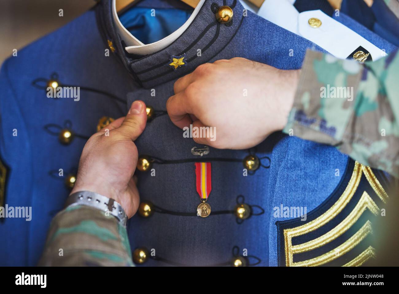 Keep your heroism close to your heart. a soldier pinning a medal to his jacket. Stock Photo