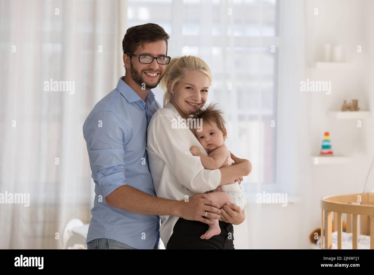 Portrait of young loving parents hugging their cute newborn baby Stock Photo