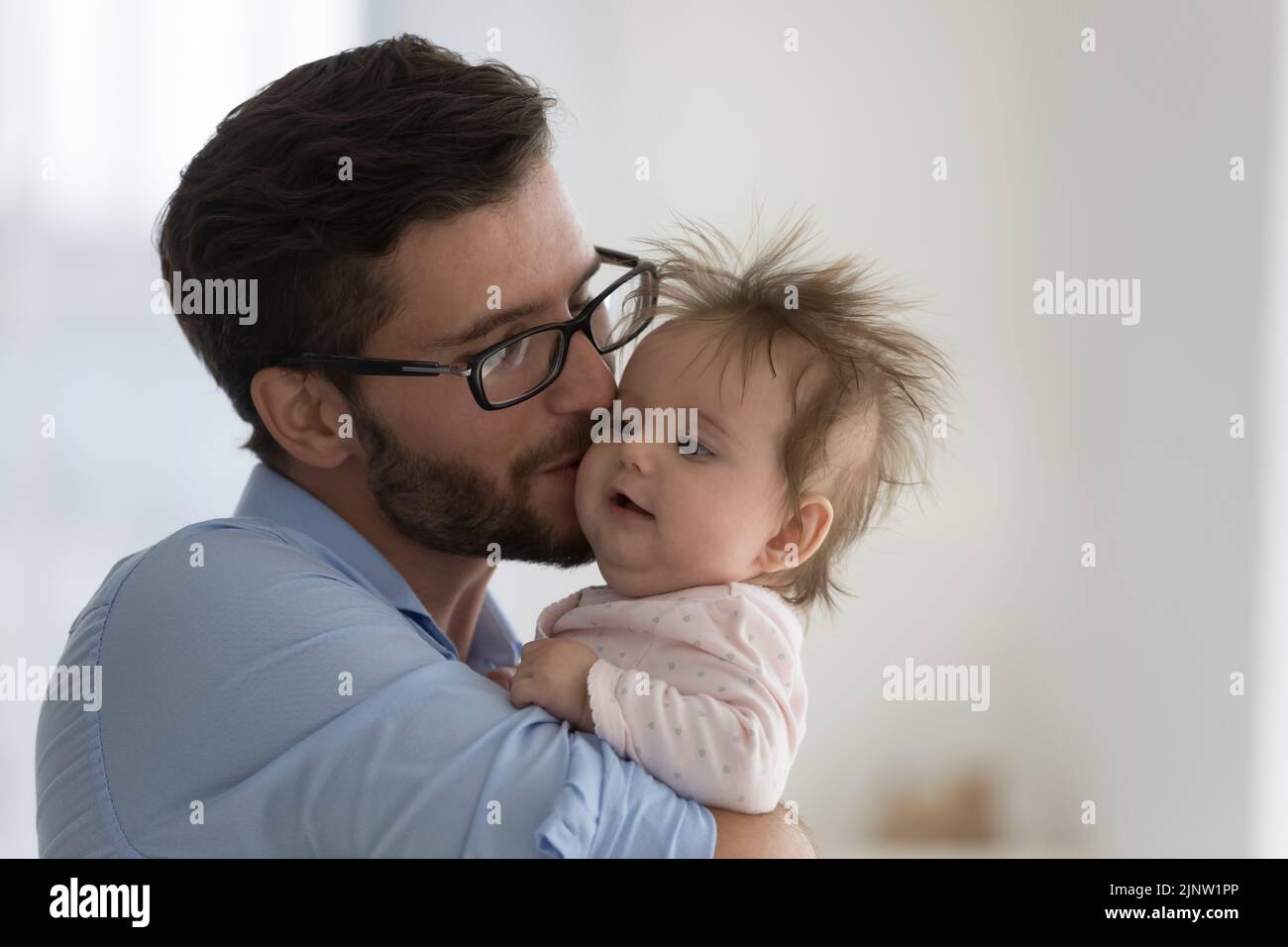 Loving daddy kisses on cheek his newborn baby Stock Photo