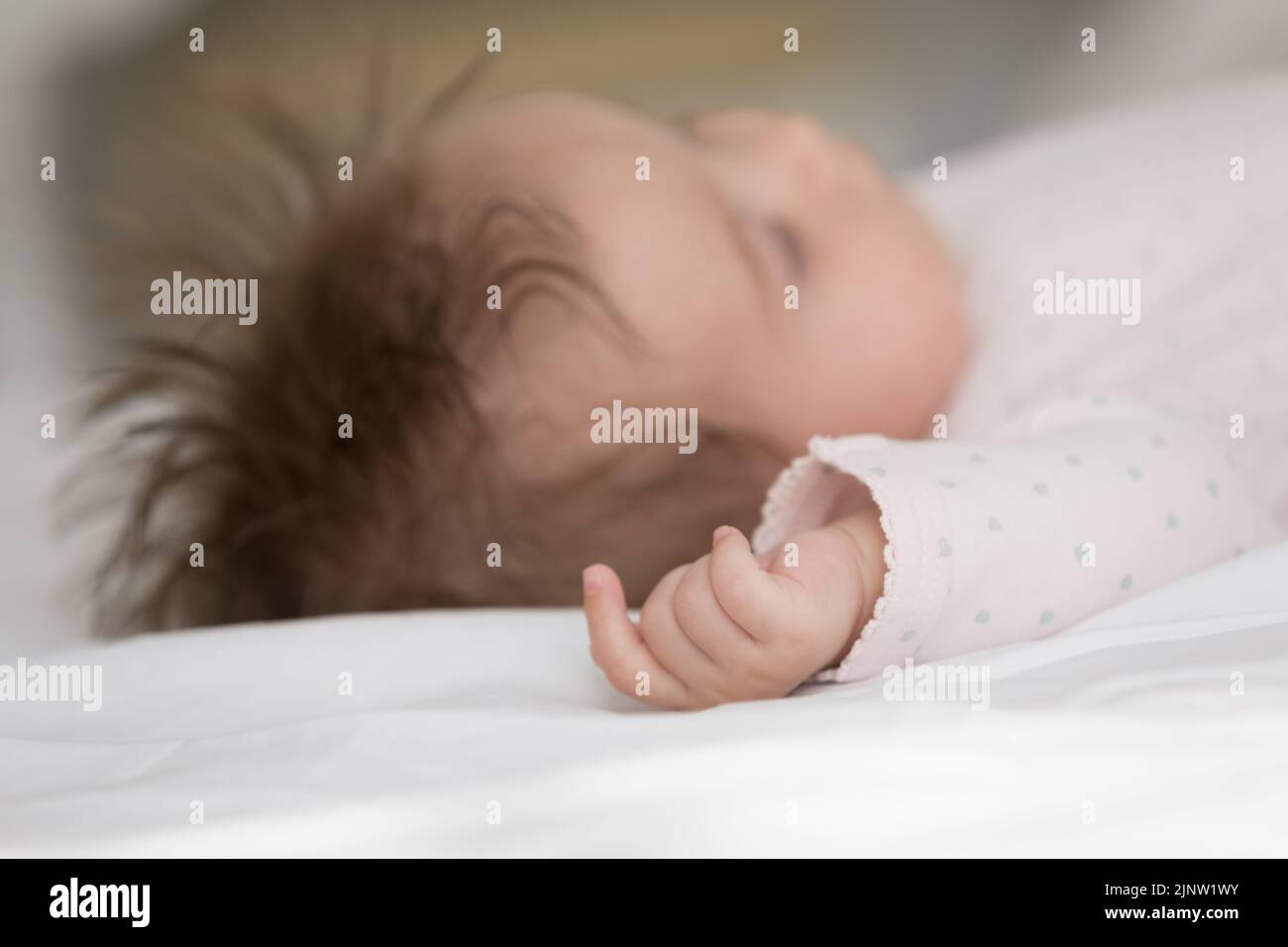 Close up new-born baby sleeping in bed Stock Photo