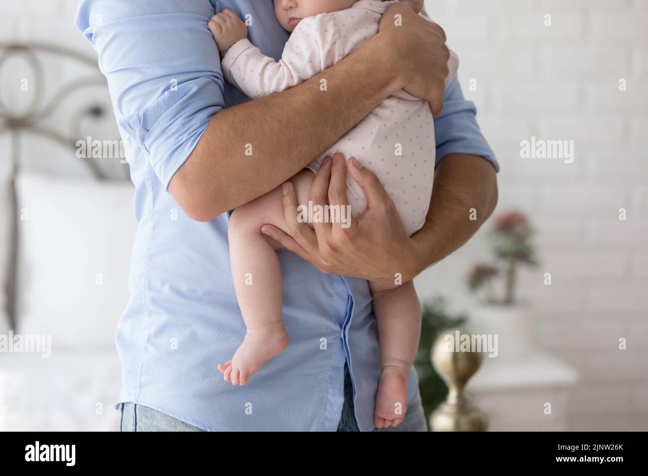 Cropped shot unknown dad holds on arms his newborn baby Stock Photo