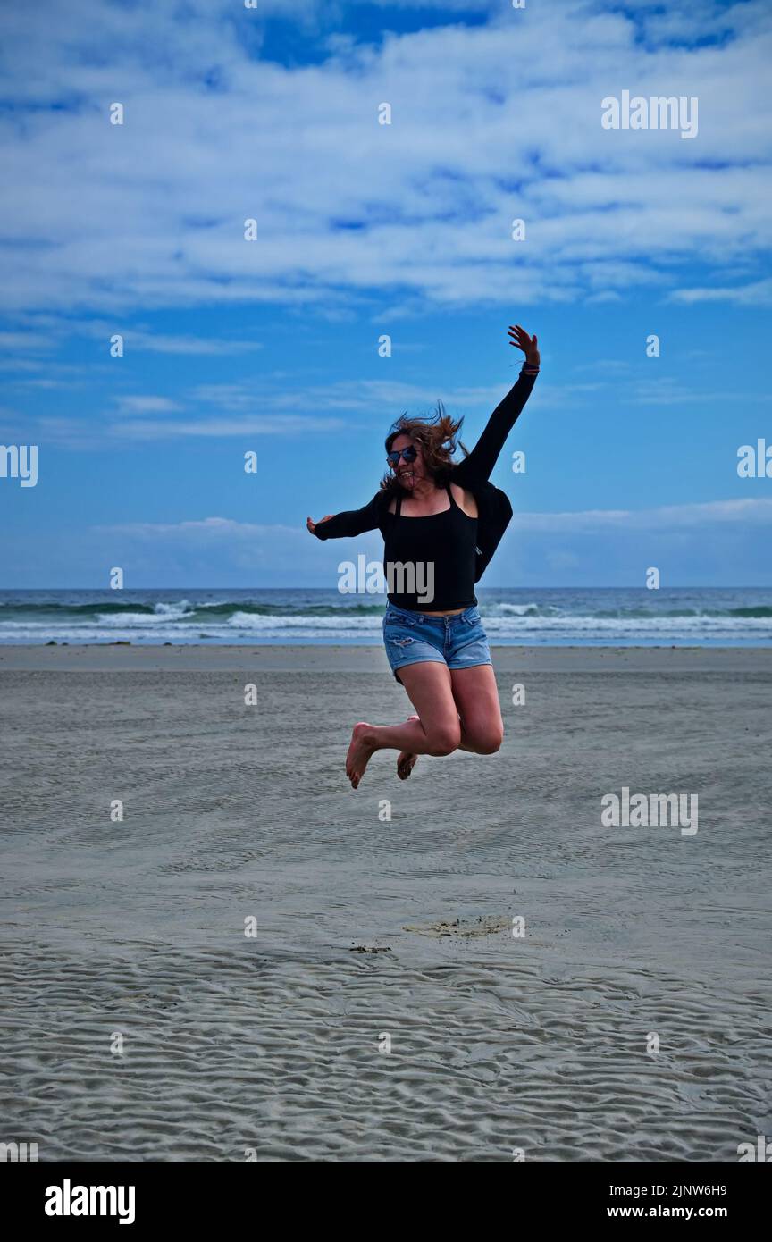 Mature woman jumping on the beach and having fun Stock Photo