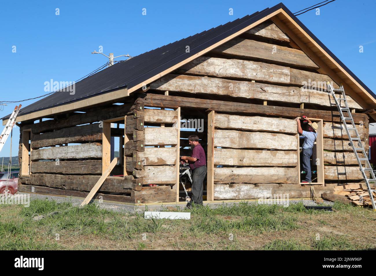 Workers from Dolittle reconstruct an 18th century log cabin at the MontourDeLong Community Fair