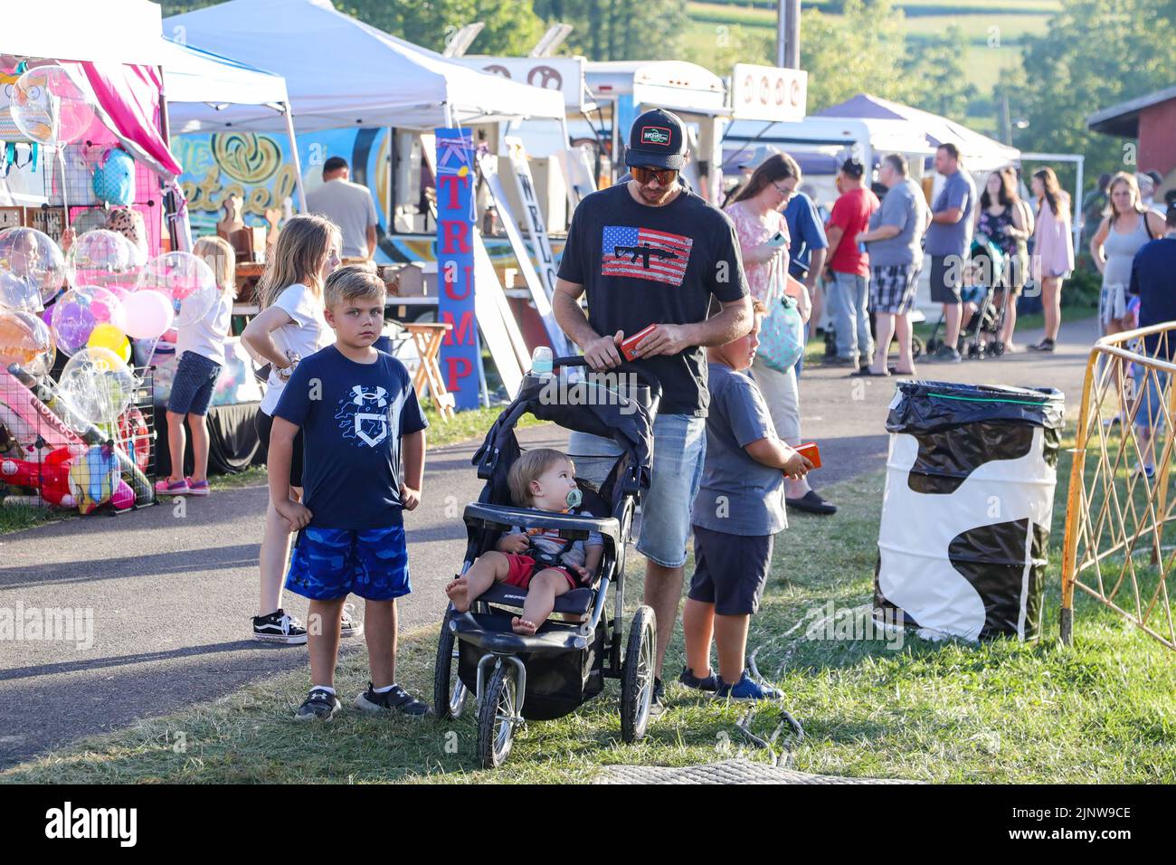People are seen on the midway at the MontourDeLong Community Fair near