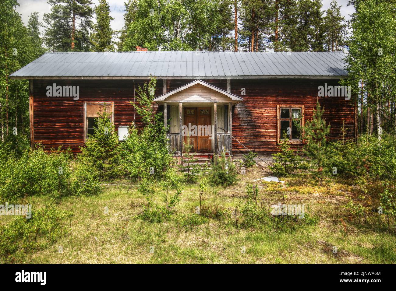 Abandoned log hut in northern Swedish forest . Stock Photo