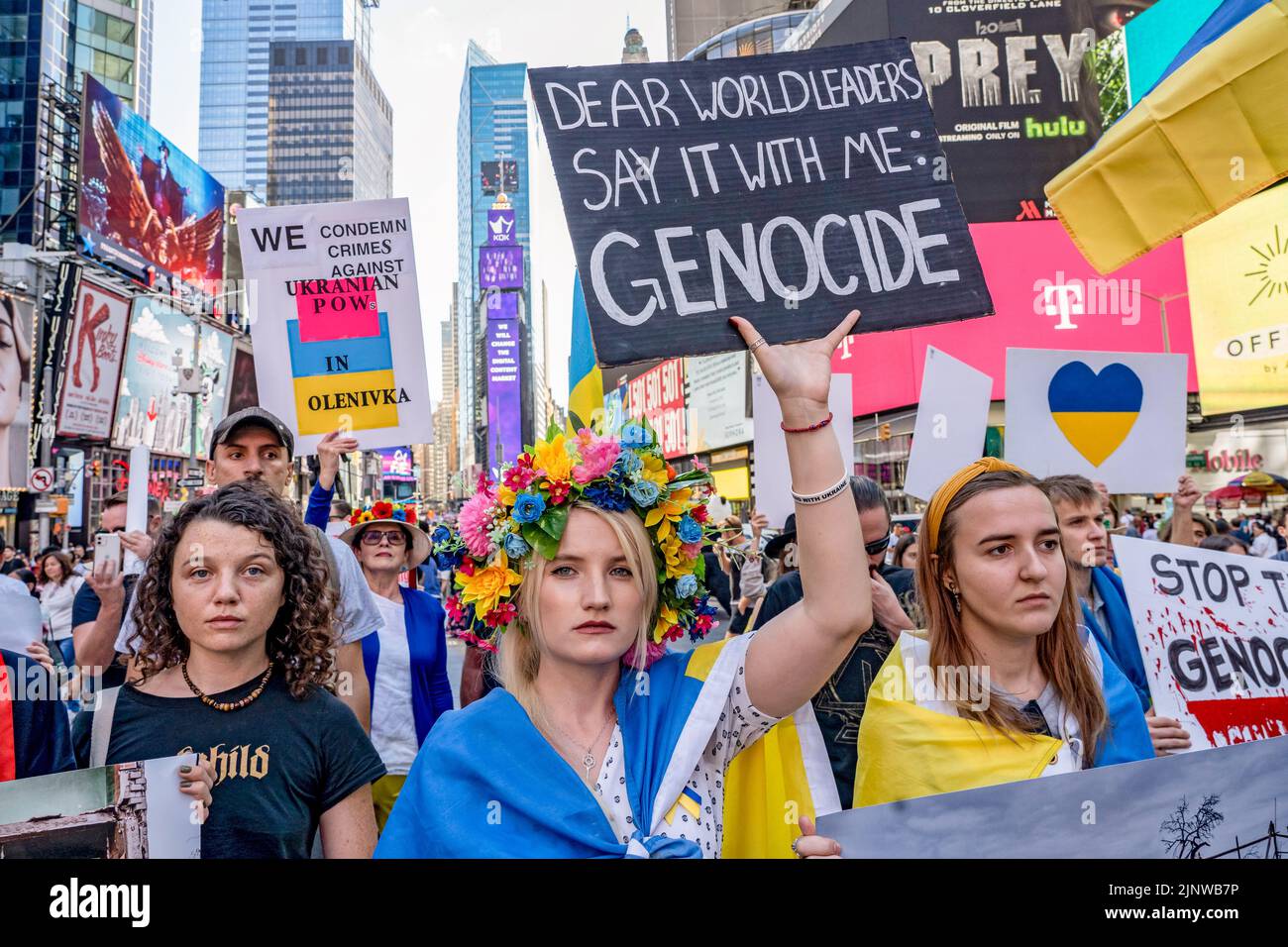 New York, United States. 13th Aug, 2022. A woman holds a 'dear world leaders say it with me: genocide' placard at a protest in support of Ukraine in Times Square in New York City. Credit: SOPA Images Limited/Alamy Live News Stock Photo