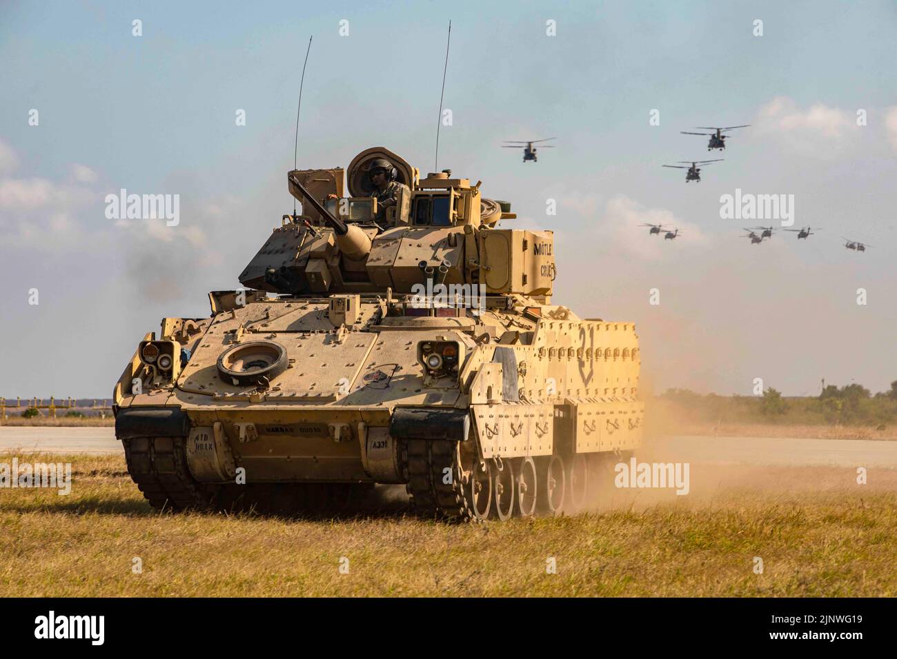 Mihail Kogalniceanu, Romania. 30th July, 2022. A Bradley Fighting Vehicle assigned to the 1st Battalion, 8th Infantry Regiment FIGHTING EAGLES 3rd Armored Brigade Combat Team, 4th Infantry Division moves into position as UH-60 Blackhawks assigned to the 3rd Battalion, 227th Aviation Regiment, 1st Air Cavalry Brigade, 1st Air Cavalry Division, conduct a fly over during an Air Assault demonstration on July 30, 2022, at Mihail Kogalniceanu, Romania. 101st units will support V Corps mission to reinforce NATO's eastern flank and engage in multinational exercises with partners across the European Stock Photo