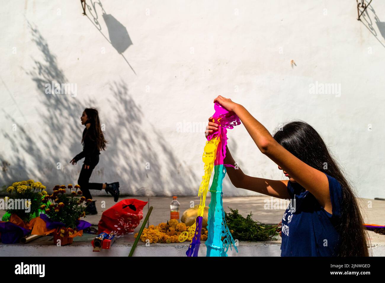 A Mexican girl prepares cut paper flags (Papel picado) for the Day of the Dead celebrations in Taxco de Alarcón, Guerrero, Mexico. Stock Photo